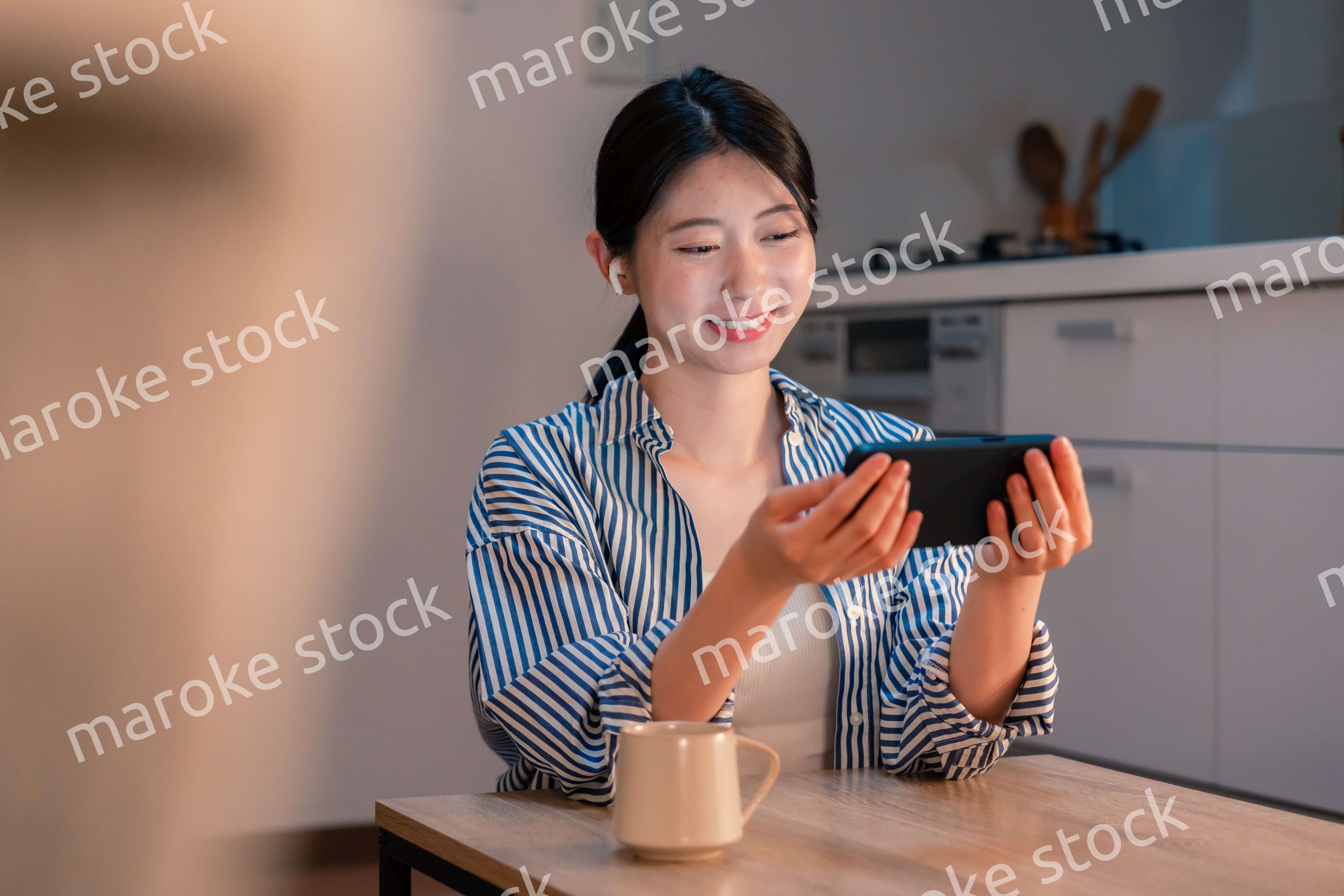 夜にスマホでコンテンツを楽しむ一人暮らしの女性