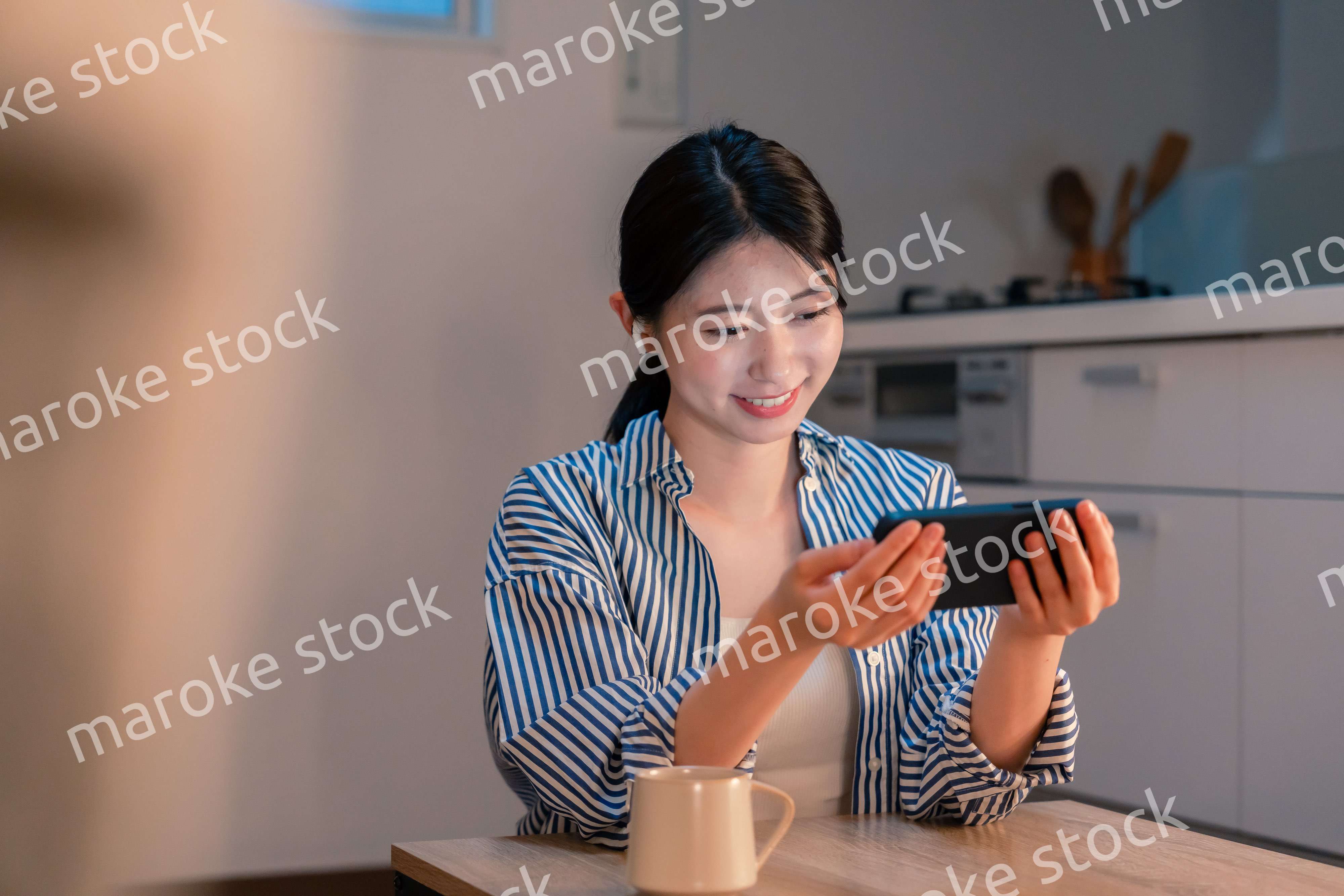 夜にスマホでコンテンツを楽しむ一人暮らしの女性