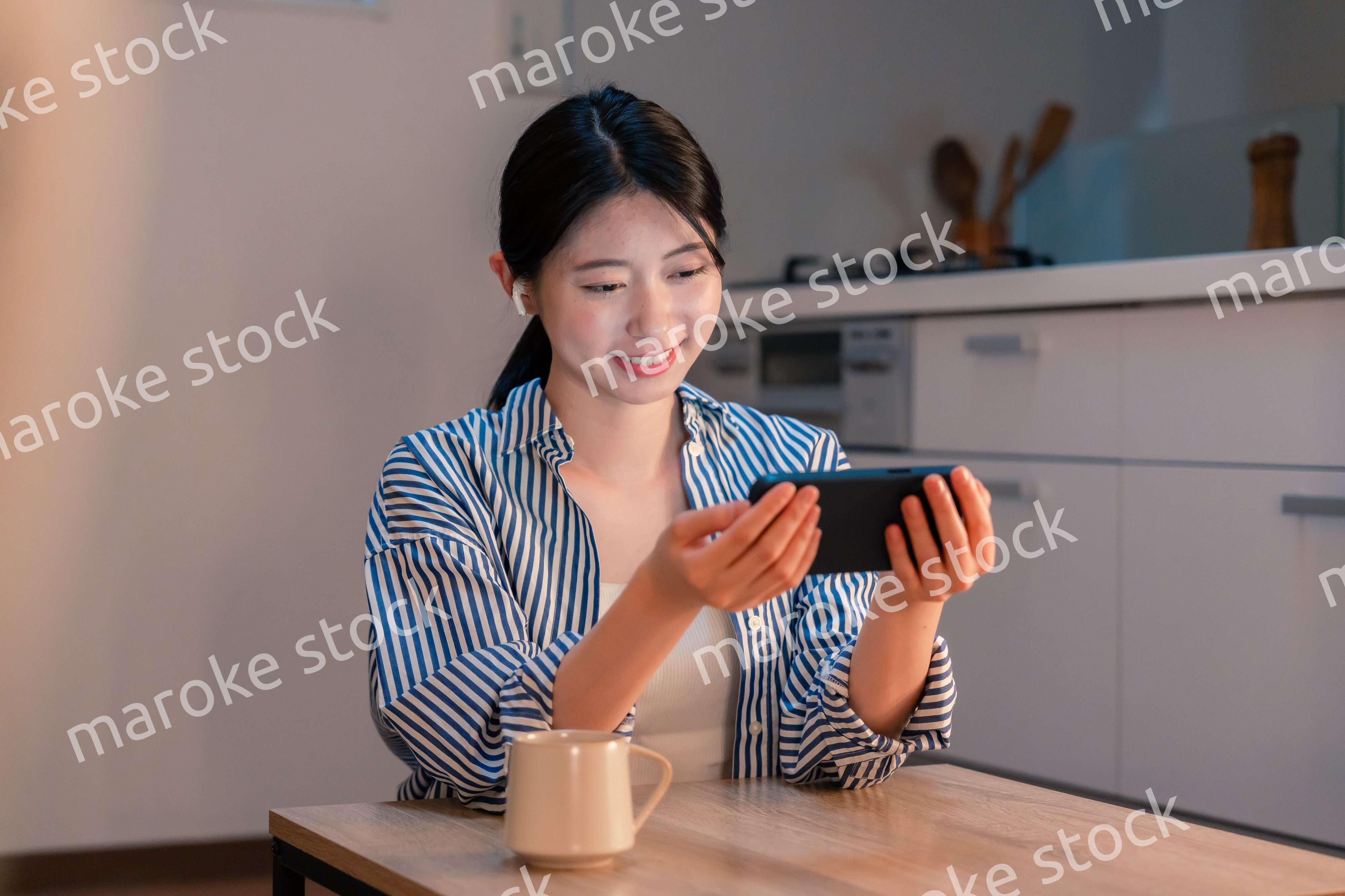 夜にスマホでコンテンツを楽しむ一人暮らしの女性