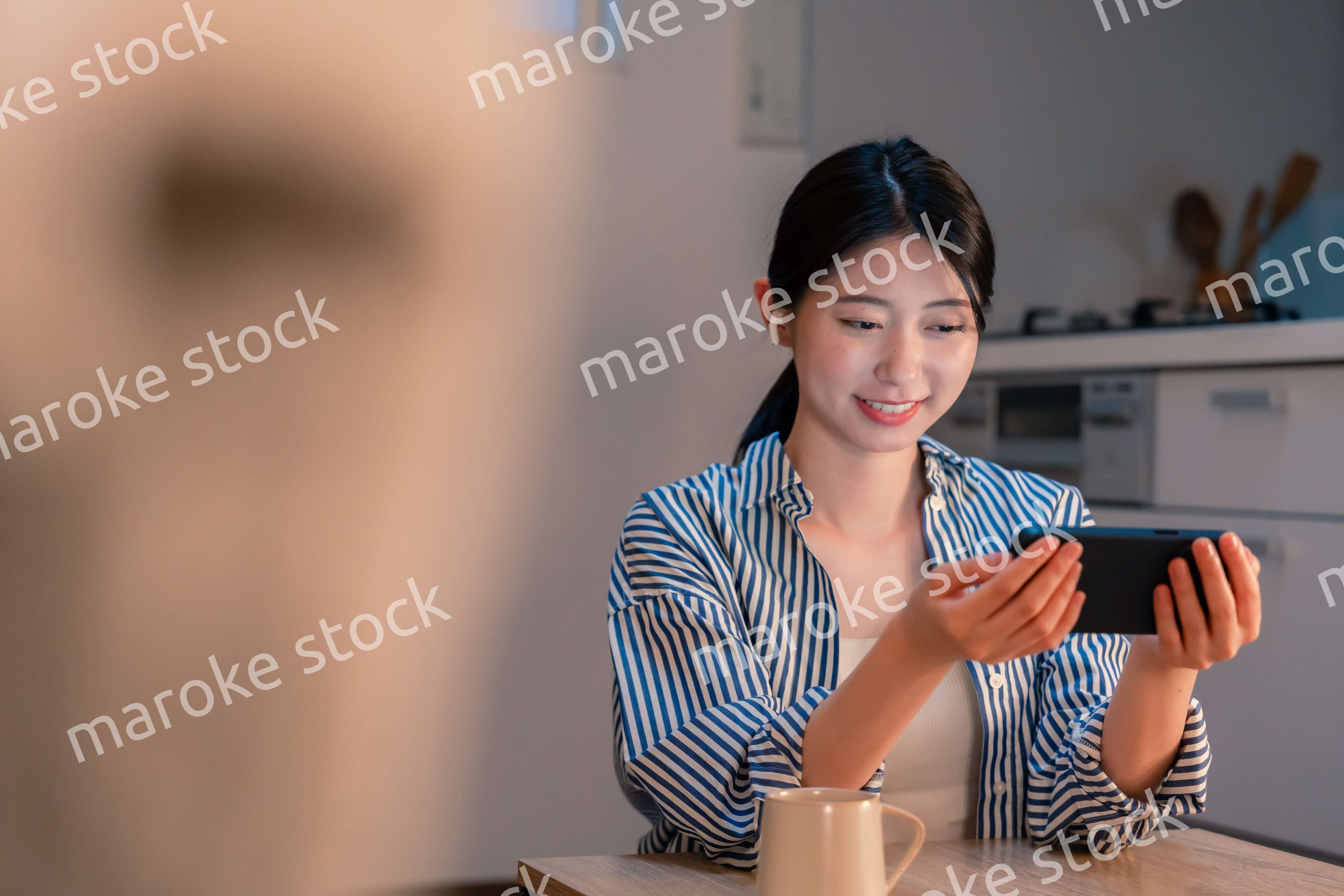 夜にスマホでコンテンツを楽しむ一人暮らしの女性