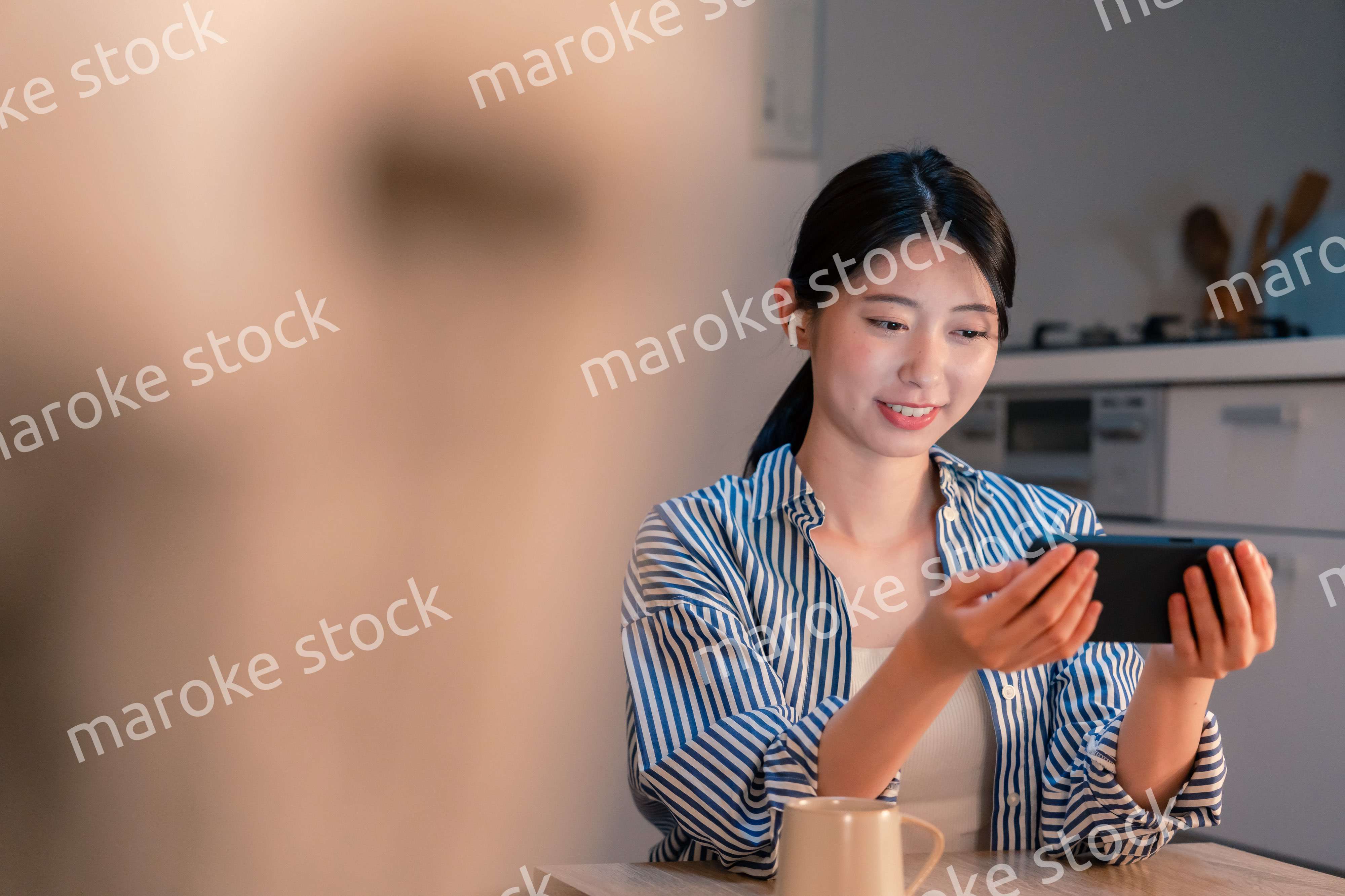 夜にスマホでコンテンツを楽しむ一人暮らしの女性