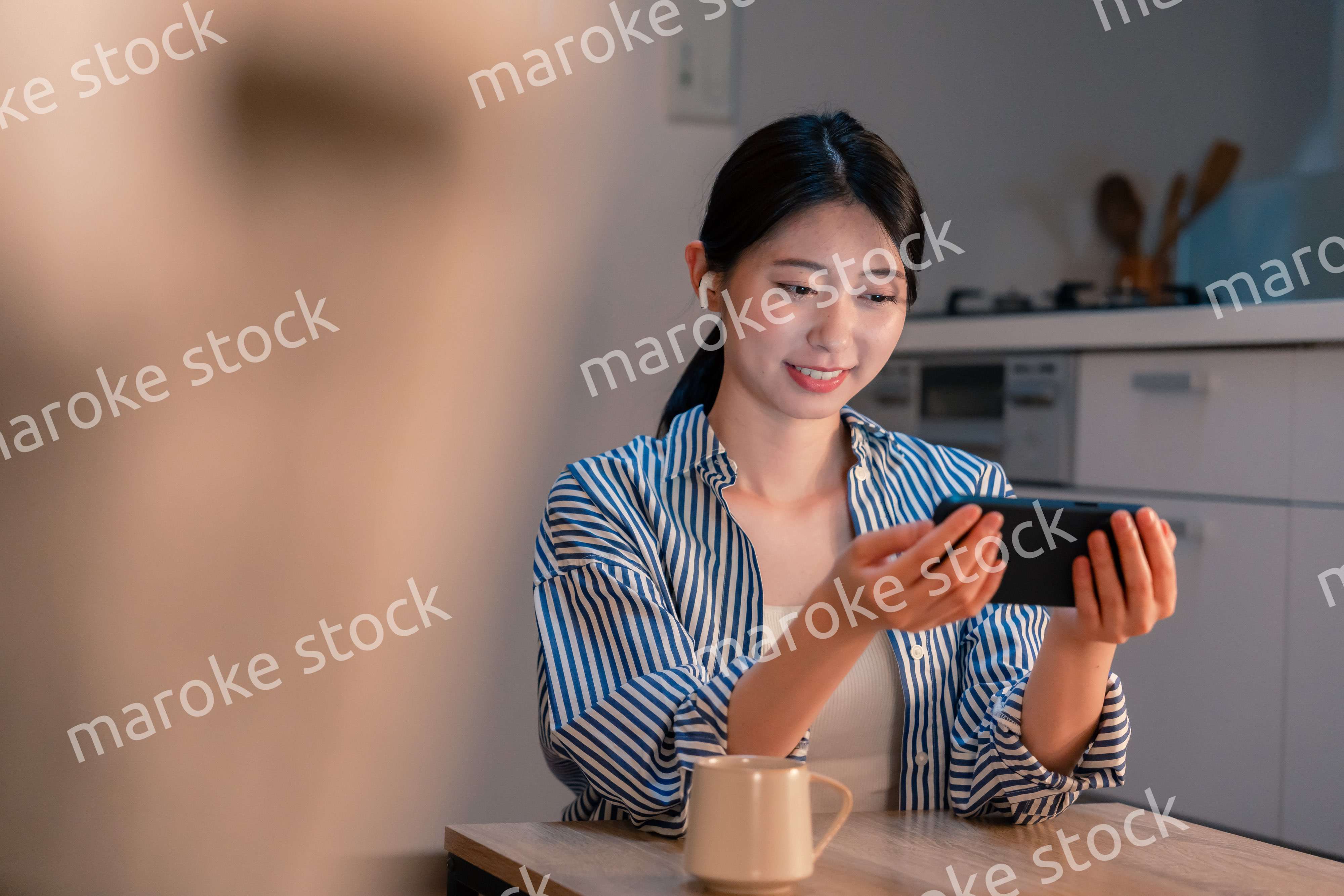 夜にスマホでコンテンツを楽しむ一人暮らしの女性