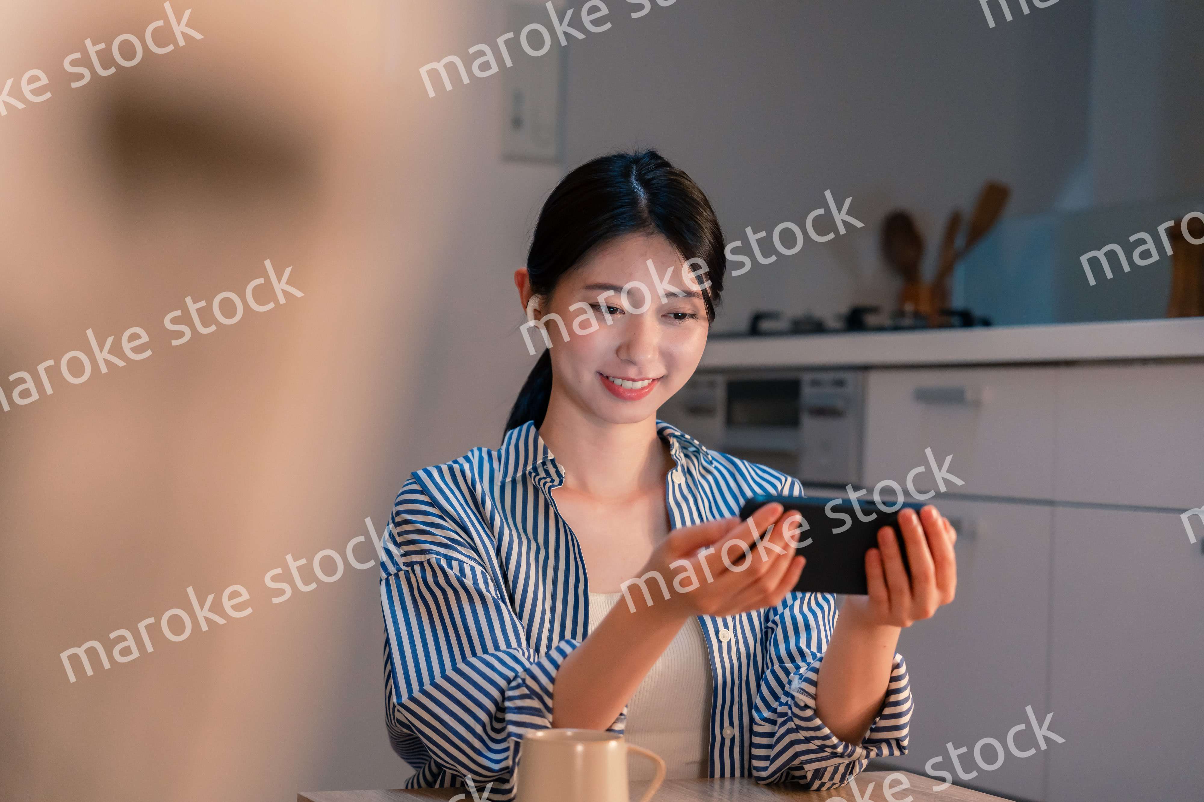 夜にスマホでコンテンツを楽しむ一人暮らしの女性