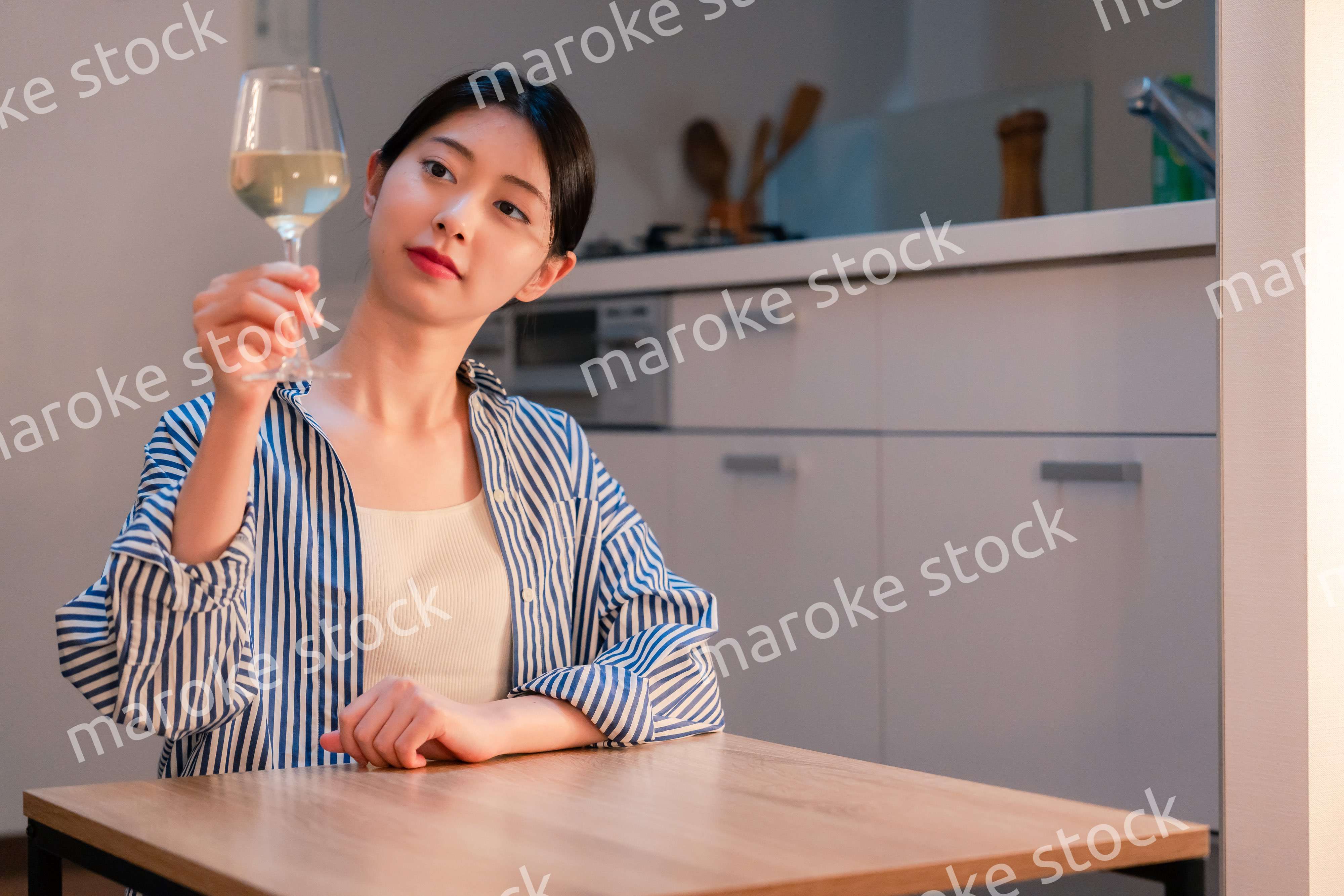 家でワインを楽しむ一人暮らしの女性