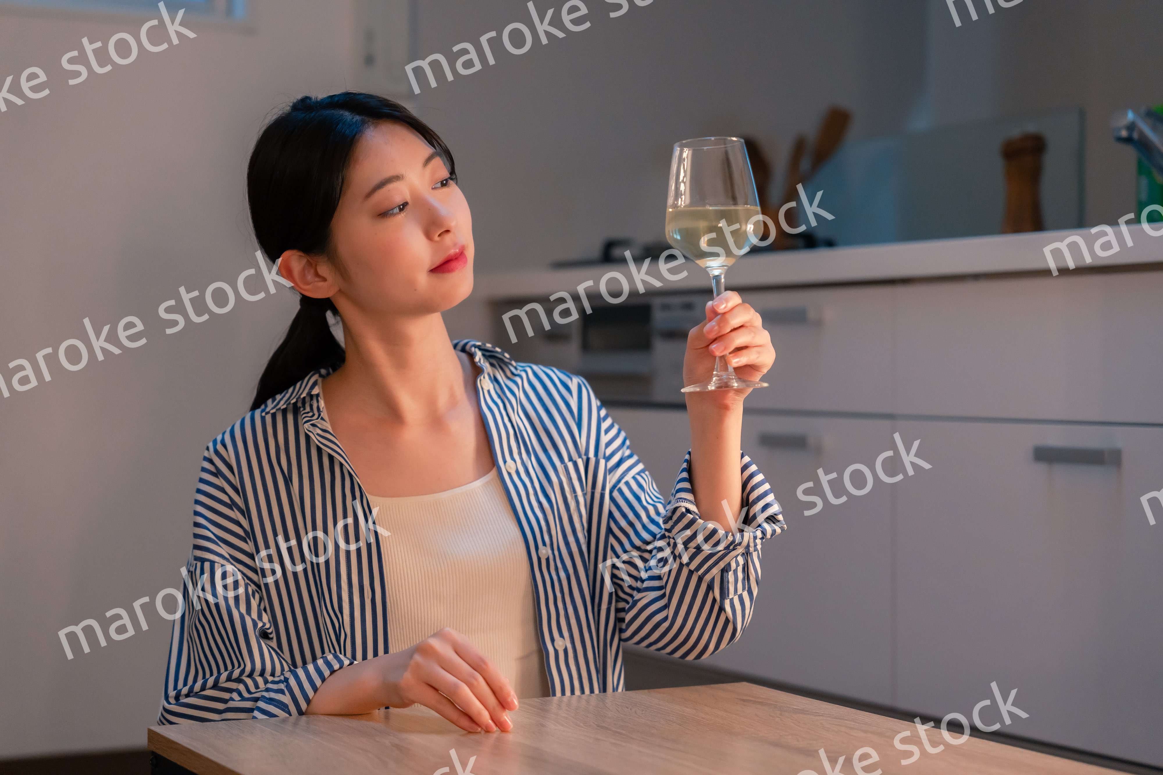 家でワインを楽しむ一人暮らしの女性