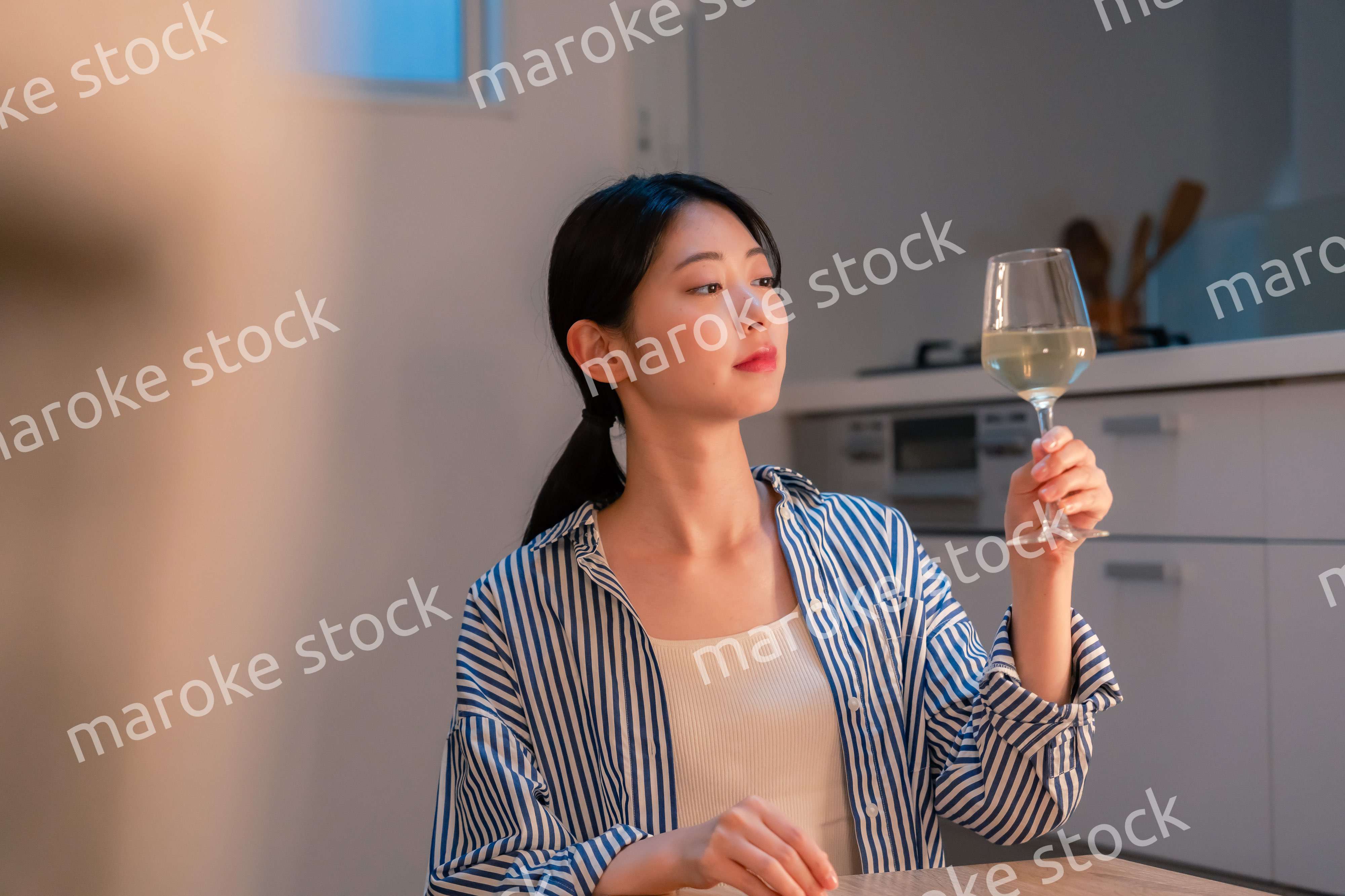 家でワインを楽しむ一人暮らしの女性
