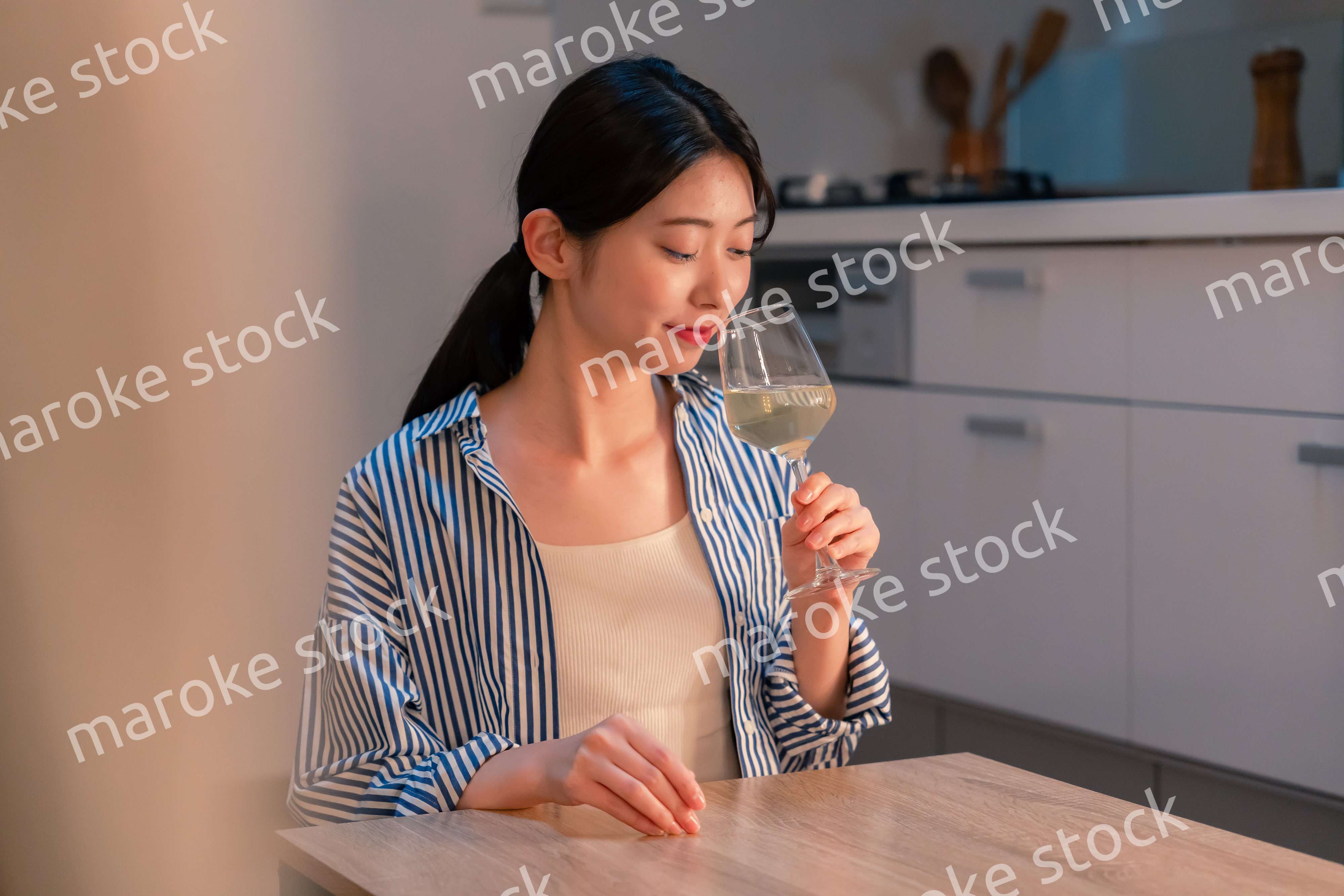 家でワインを楽しむ一人暮らしの女性
