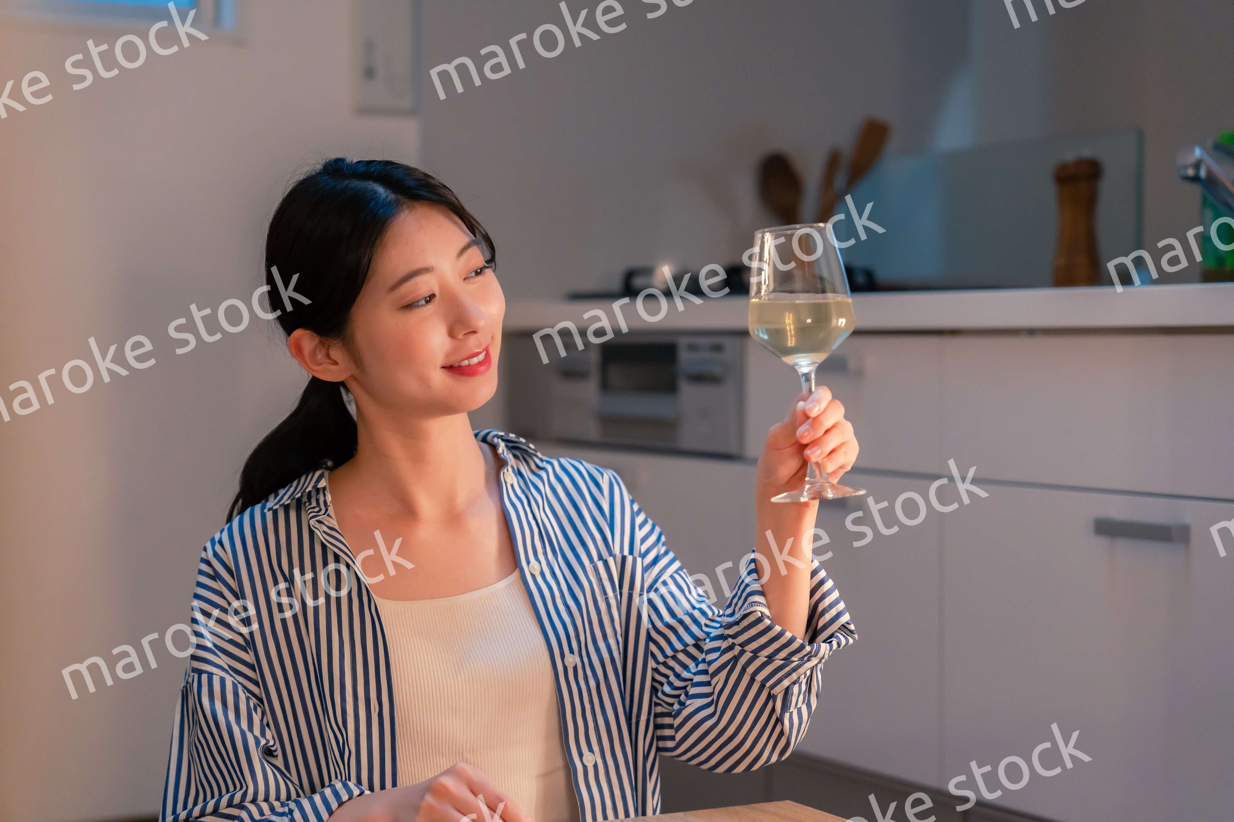 家でワインを楽しむ一人暮らしの女性