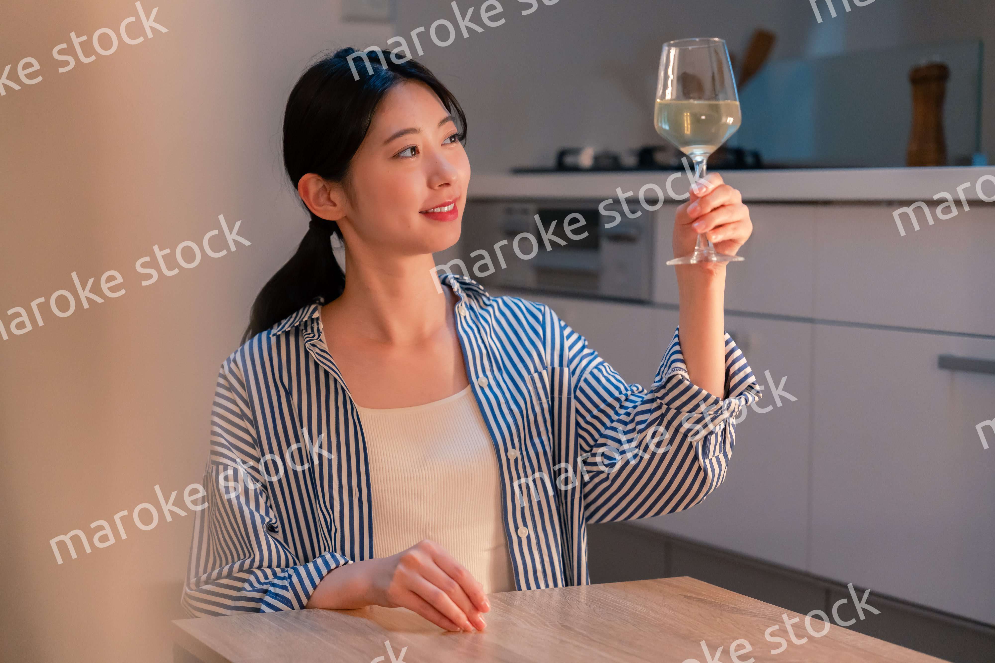 家でワインを楽しむ一人暮らしの女性
