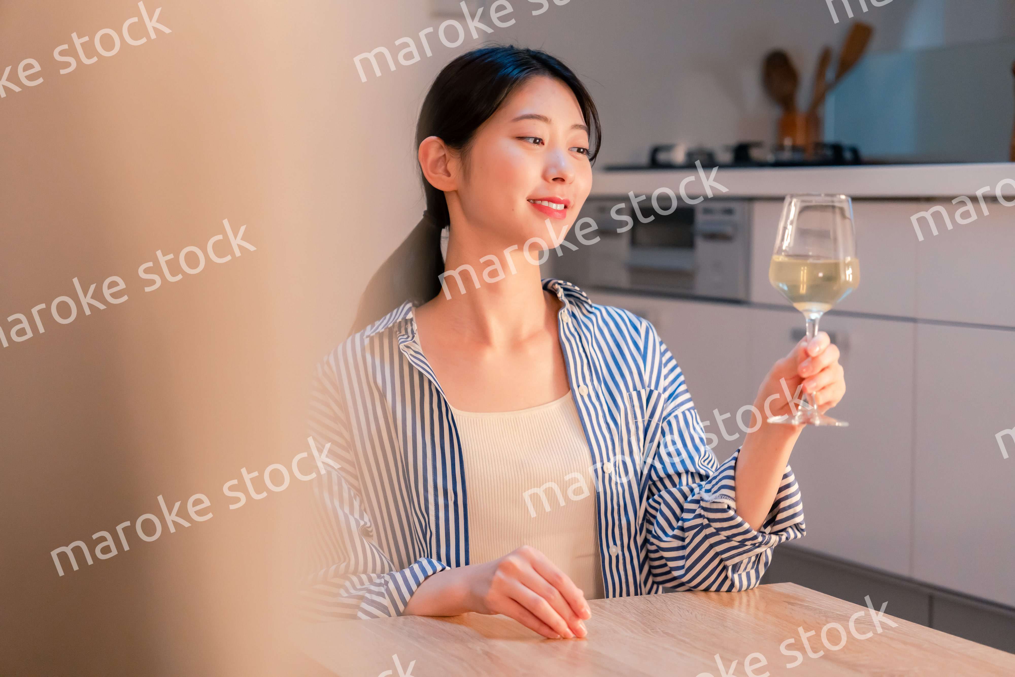 家でワインを楽しむ一人暮らしの女性