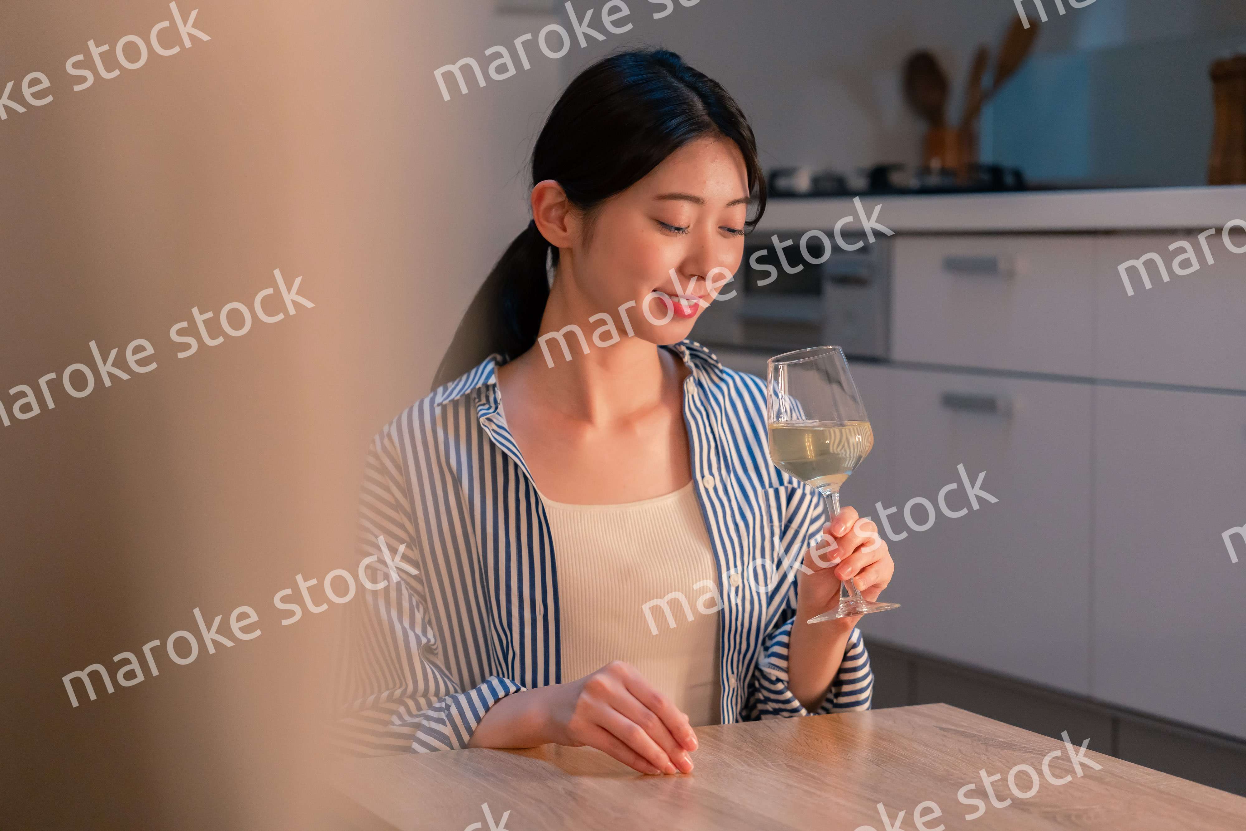 家でワインを楽しむ一人暮らしの女性