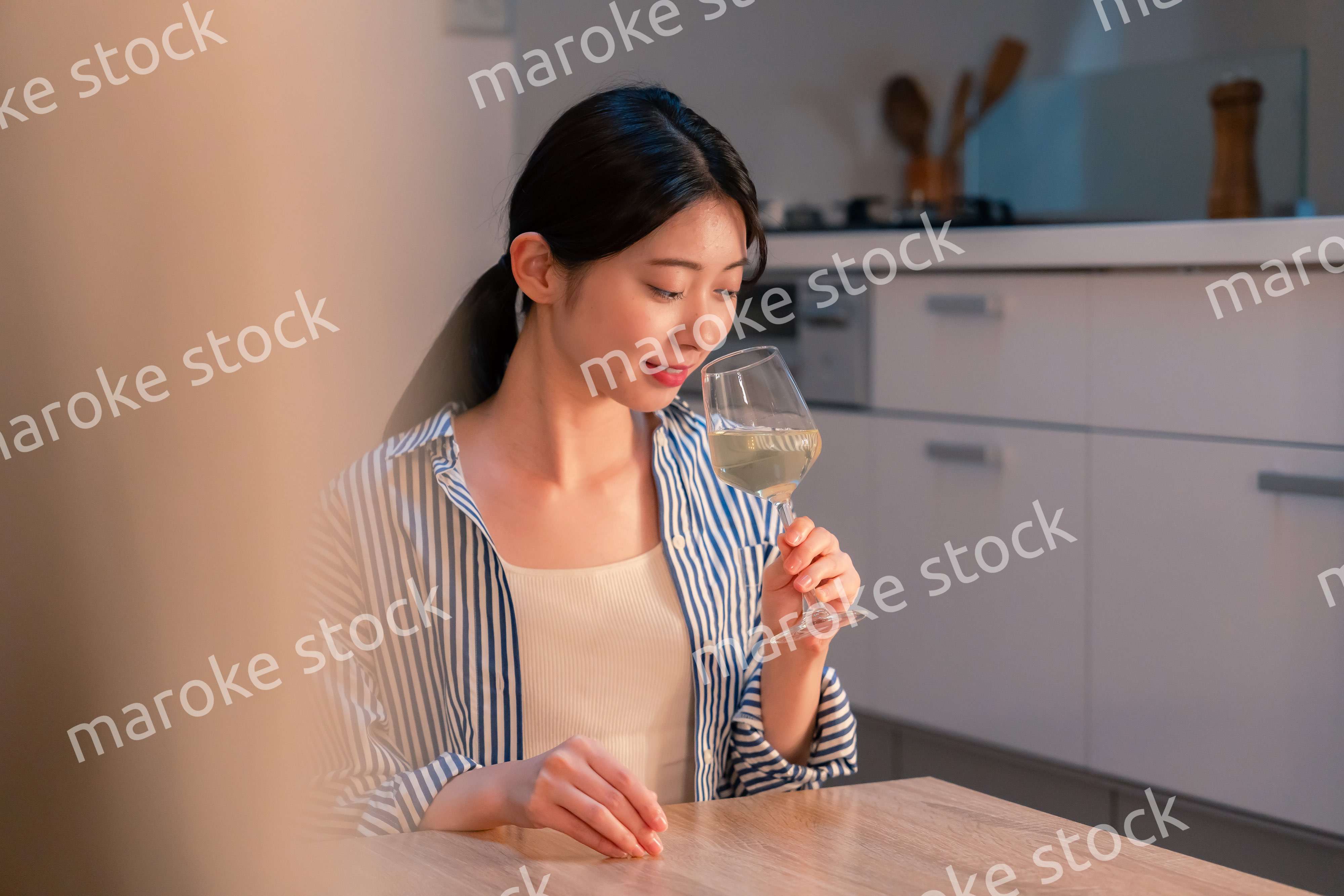 家でワインを楽しむ一人暮らしの女性