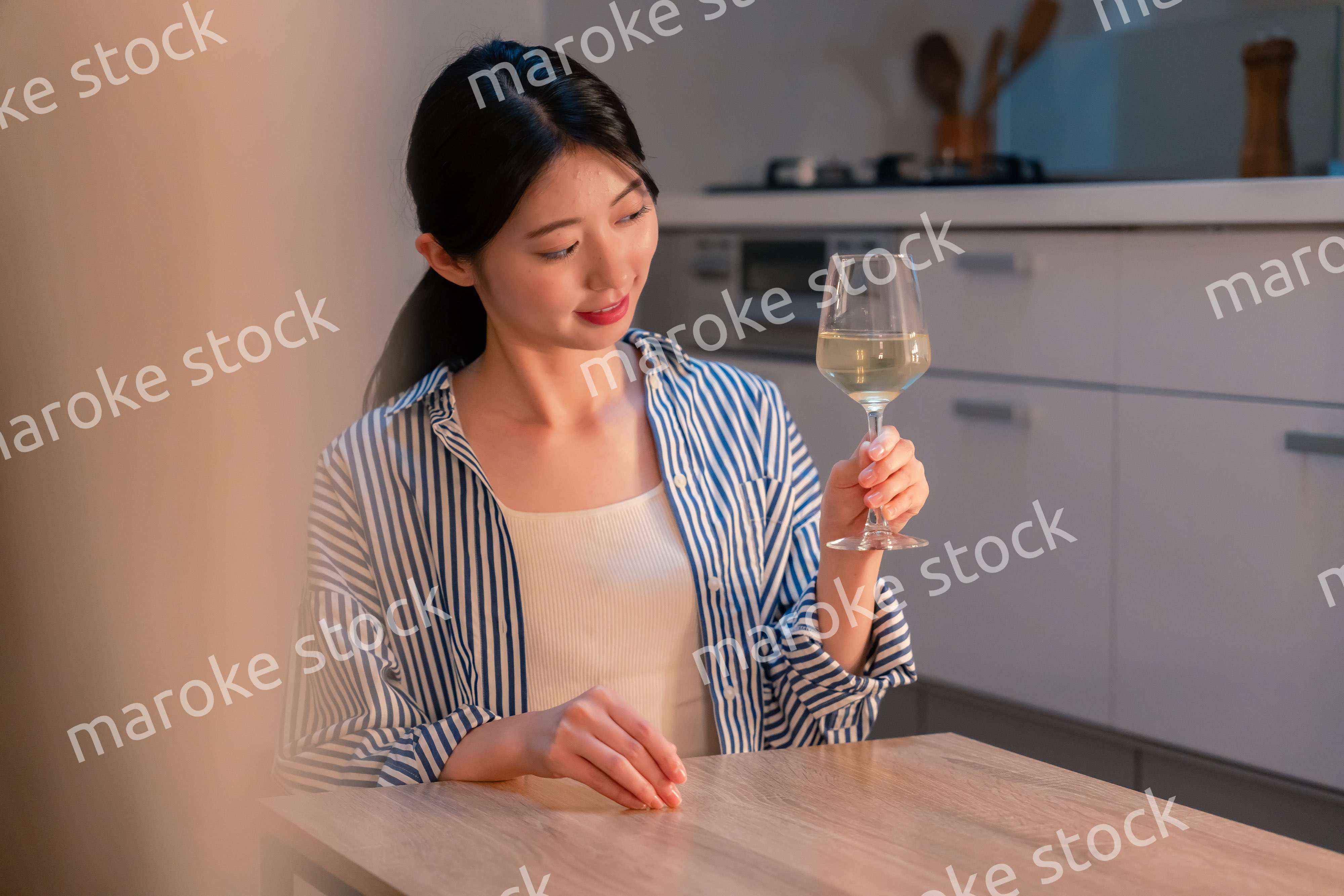 家でワインを楽しむ一人暮らしの女性