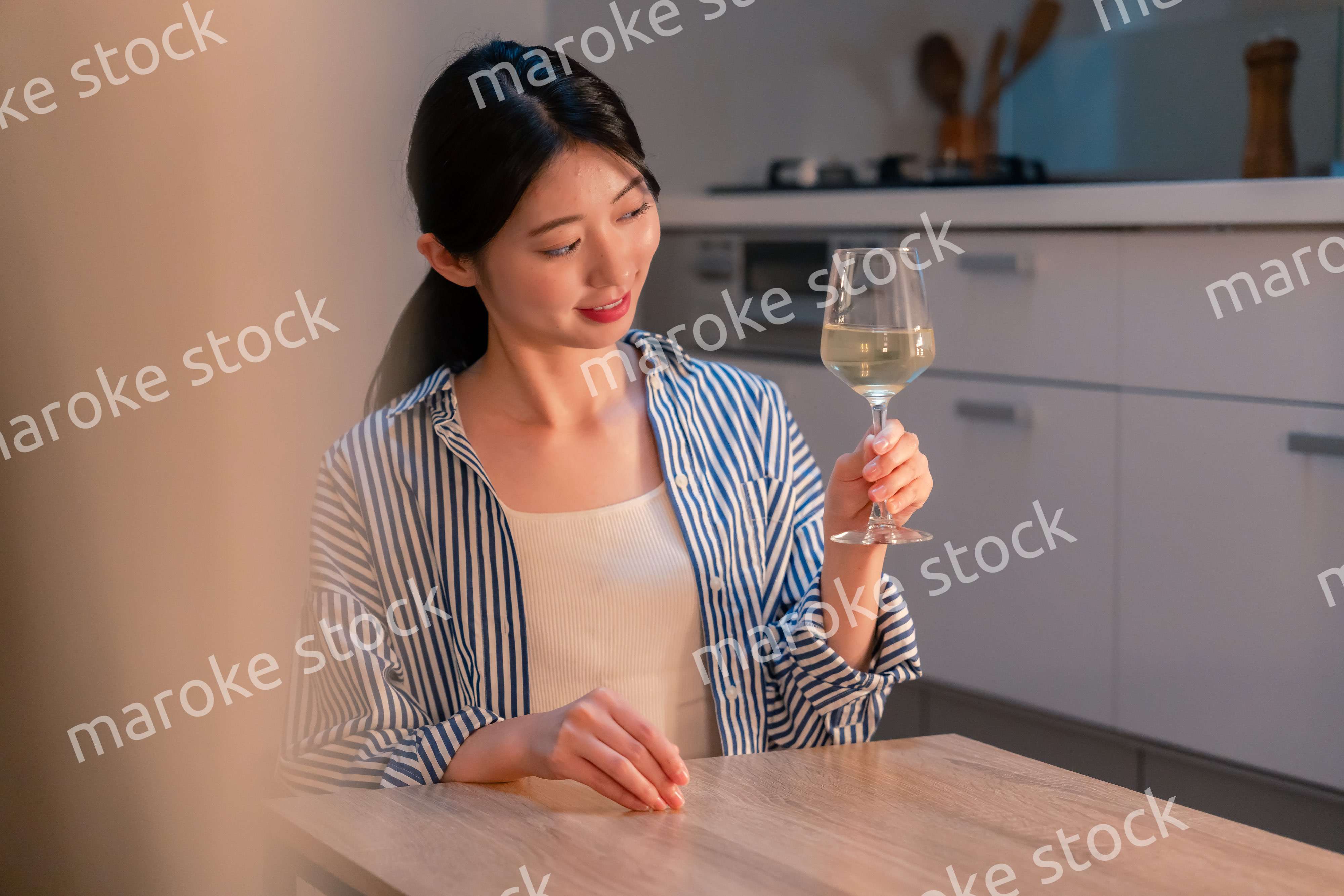 家でワインを楽しむ一人暮らしの女性