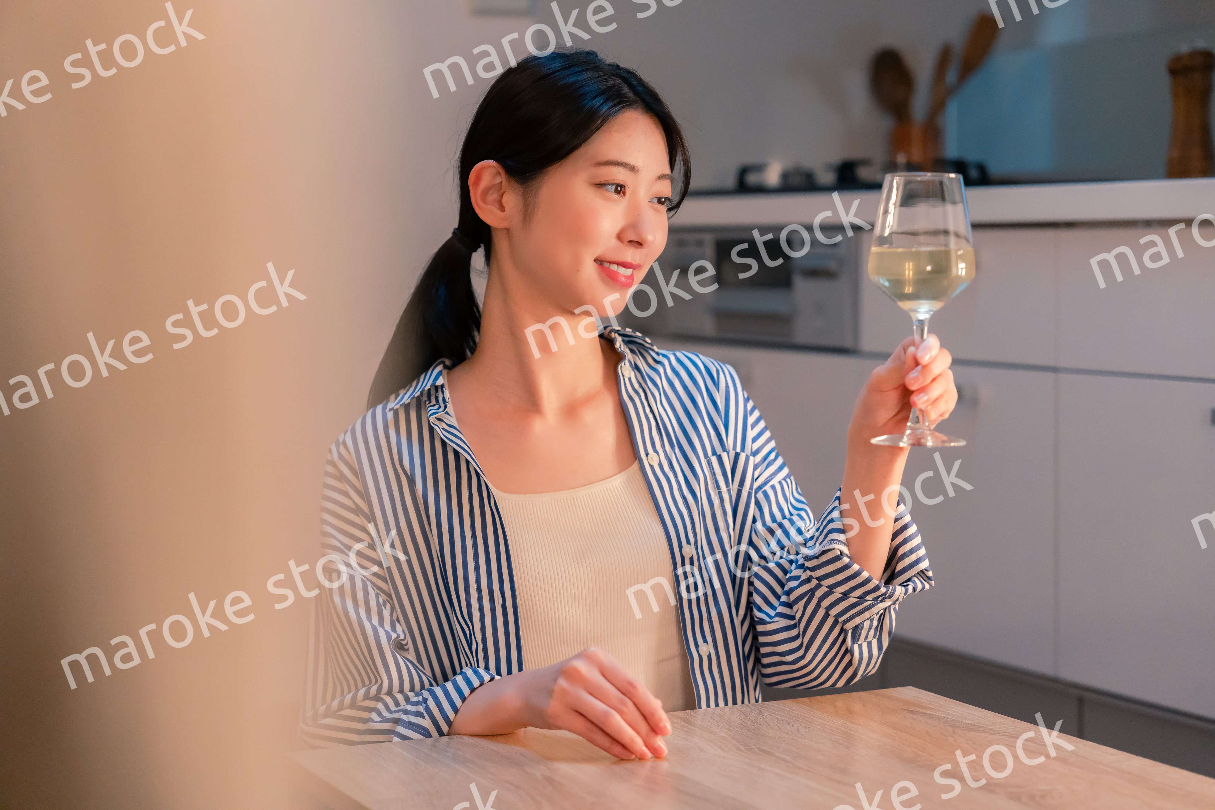家でワインを楽しむ一人暮らしの女性