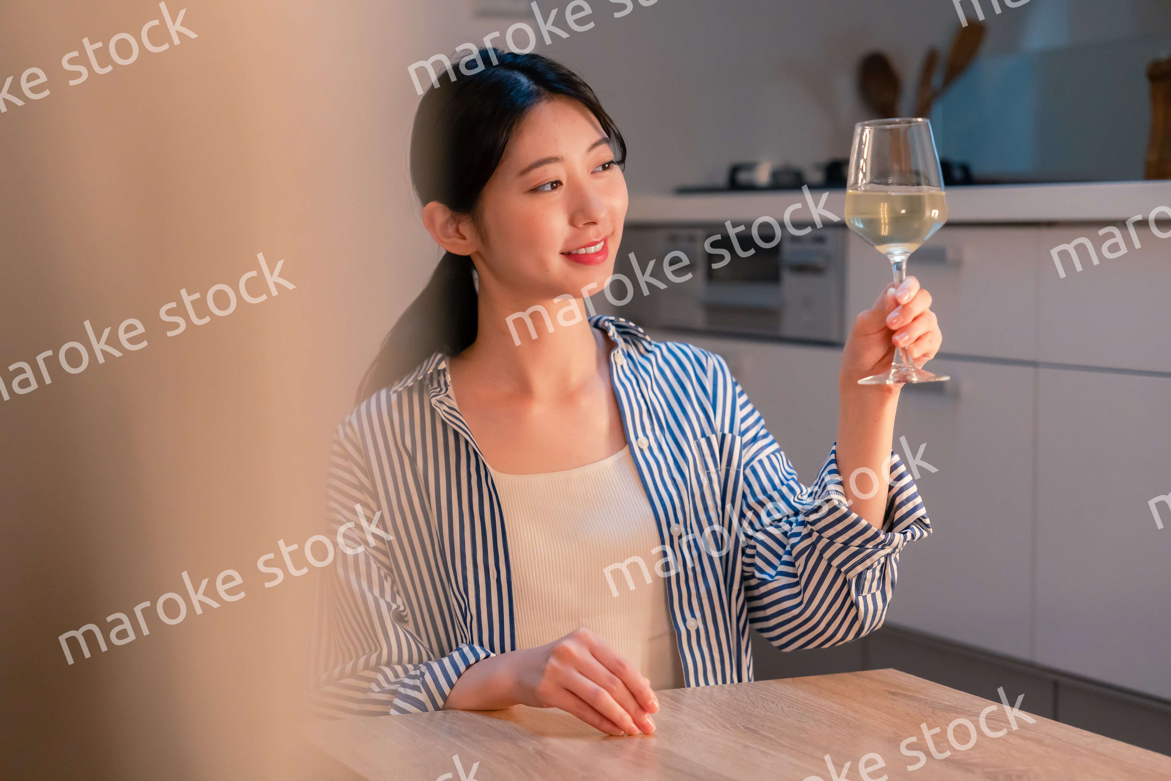 家でワインを楽しむ一人暮らしの女性