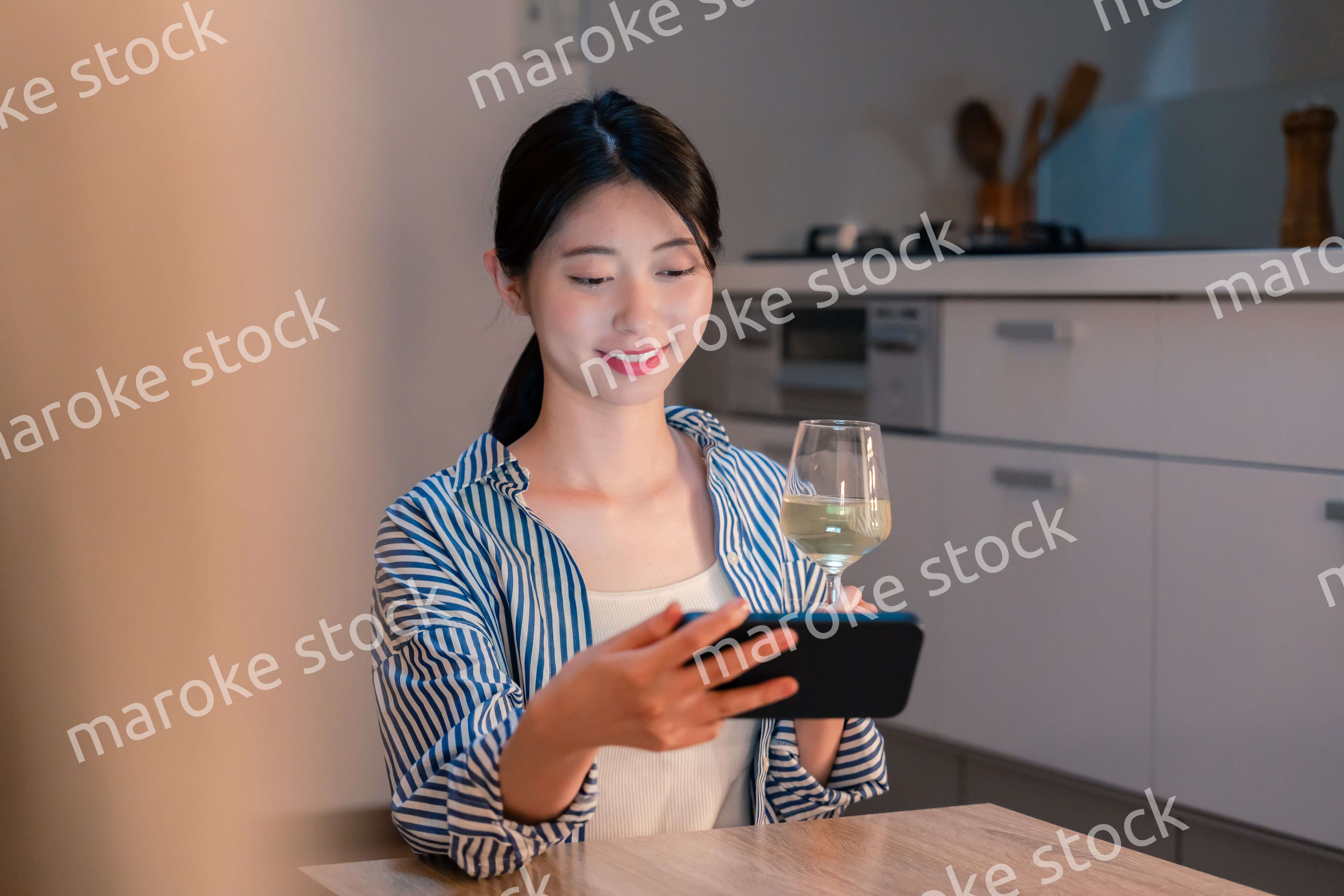 夜に一人で晩酌をする若い女性