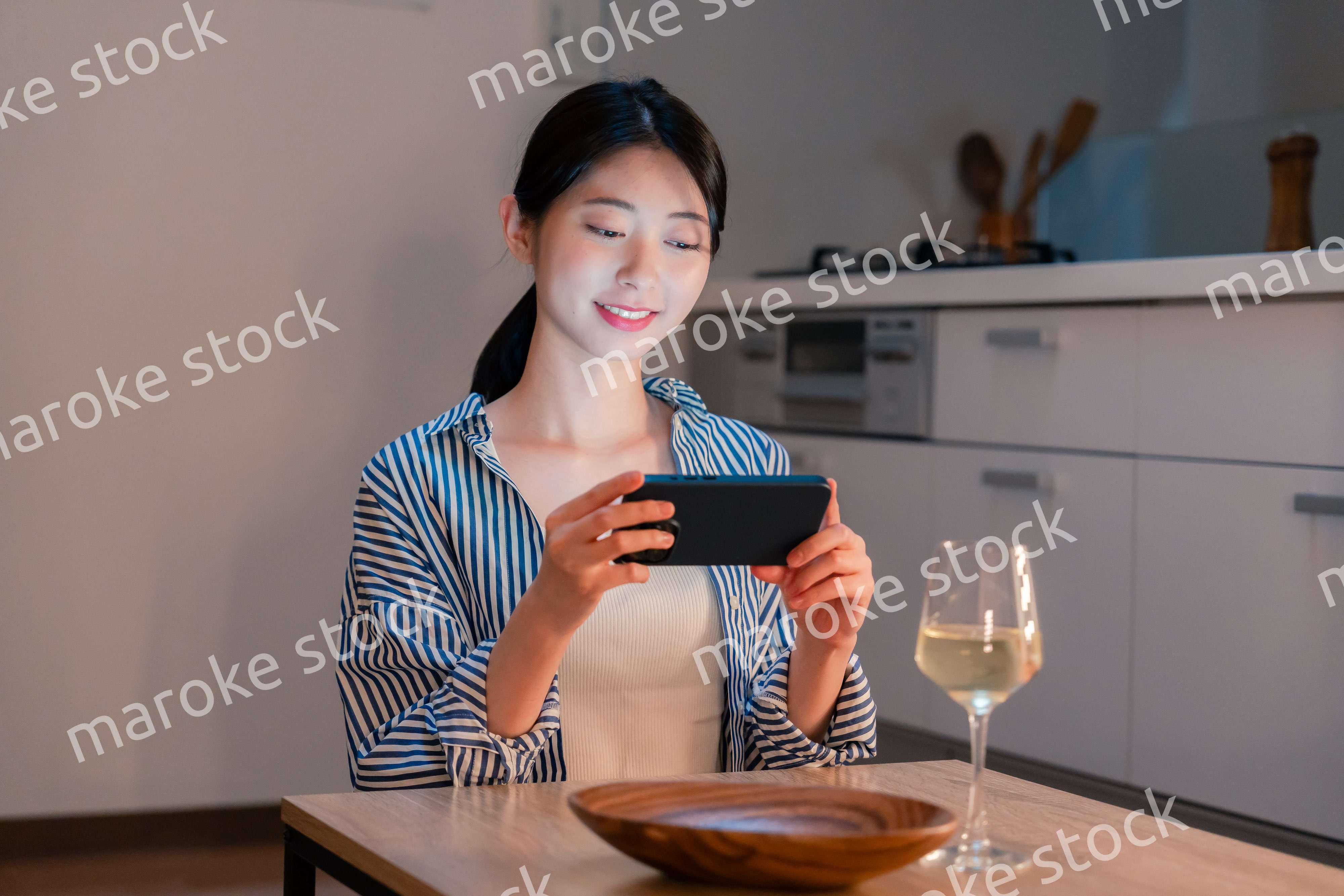 夜に一人で晩酌をする若い女性