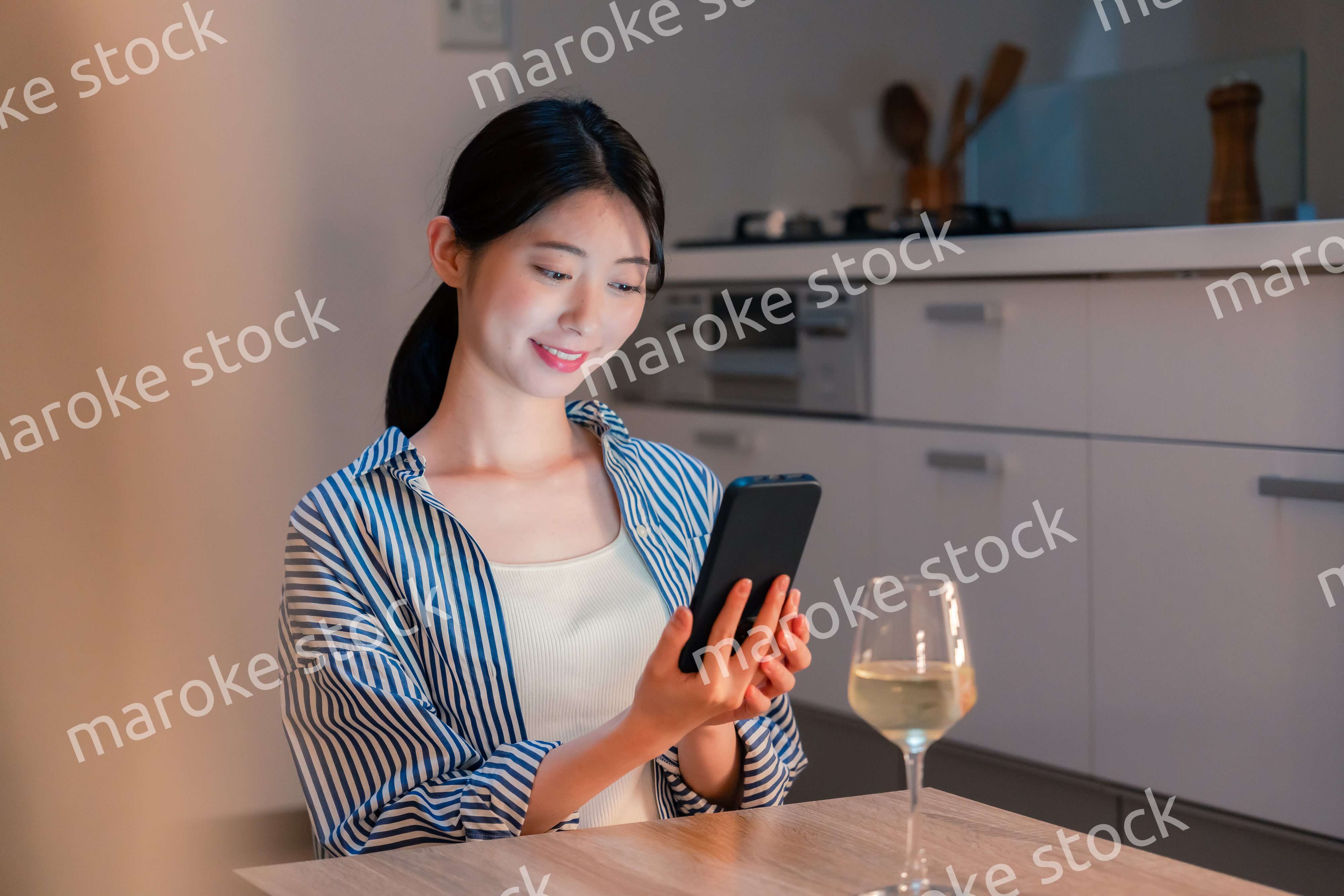 夜に一人で晩酌をする若い女性