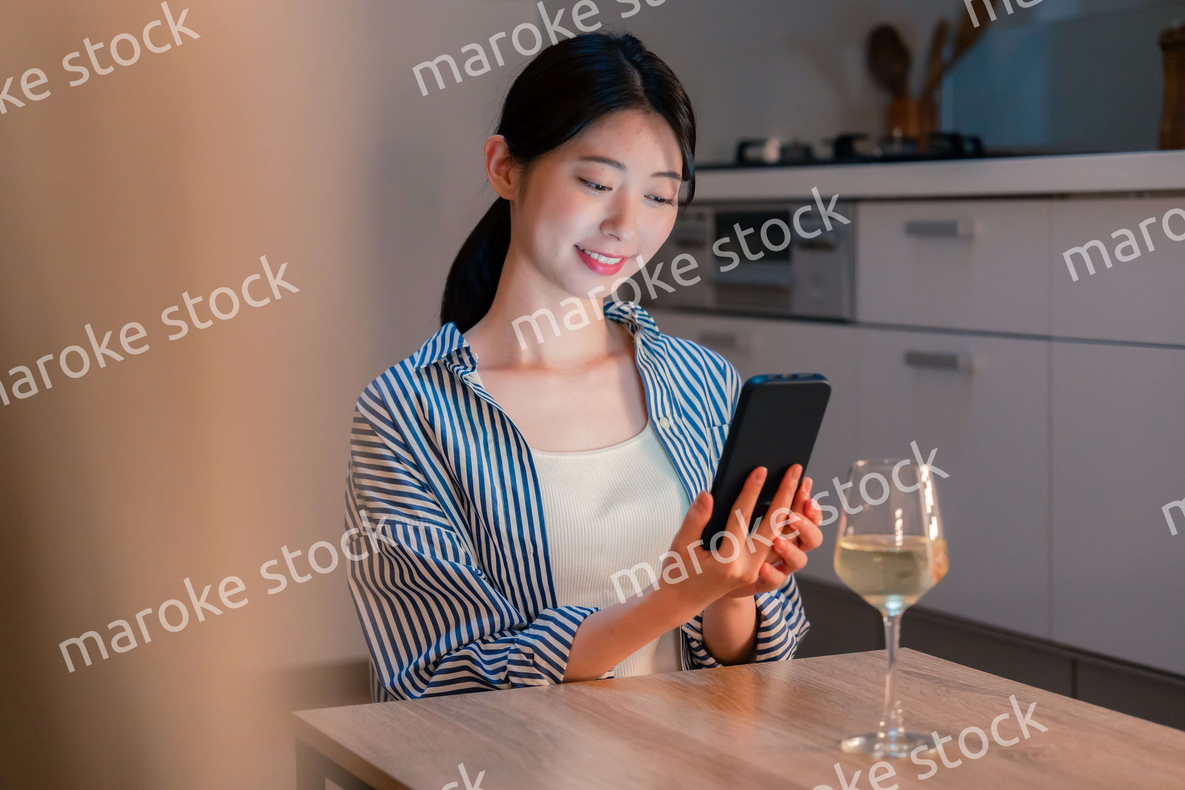 夜に一人で晩酌をする若い女性