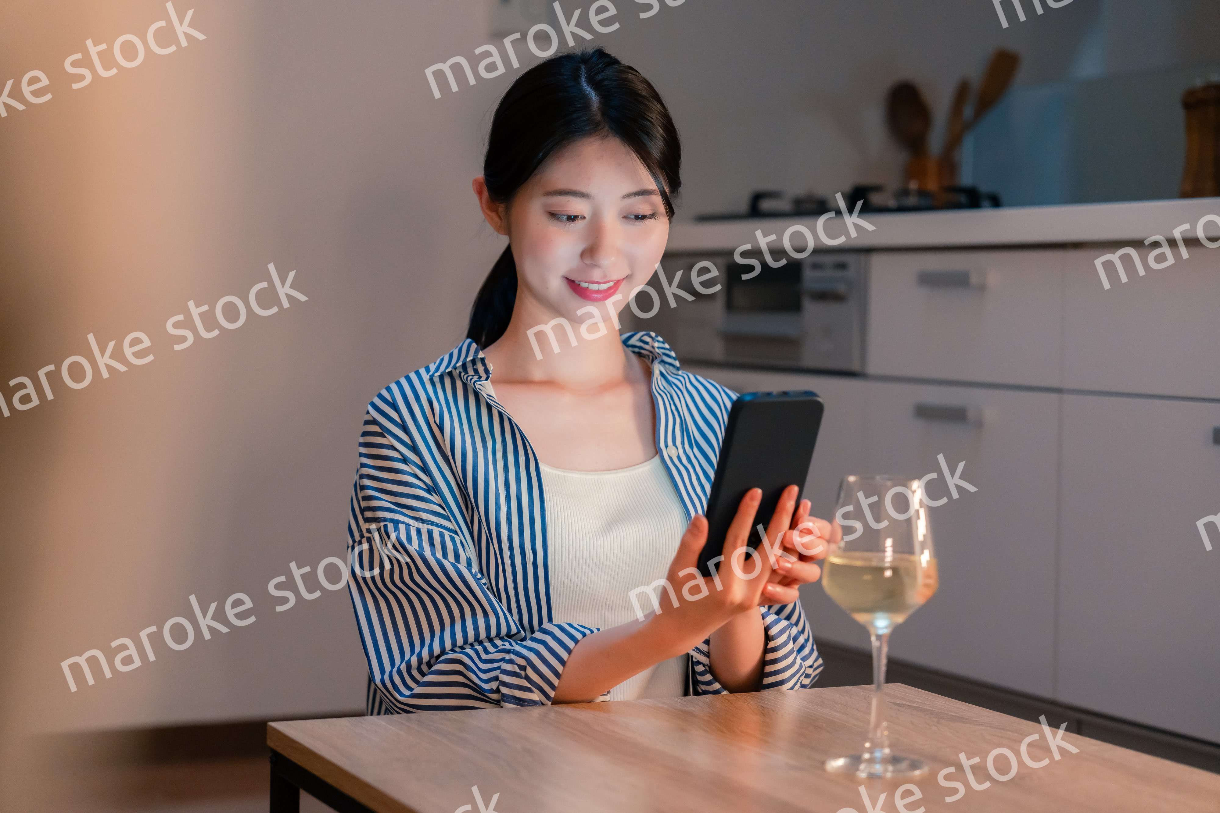 夜に一人で晩酌をする若い女性