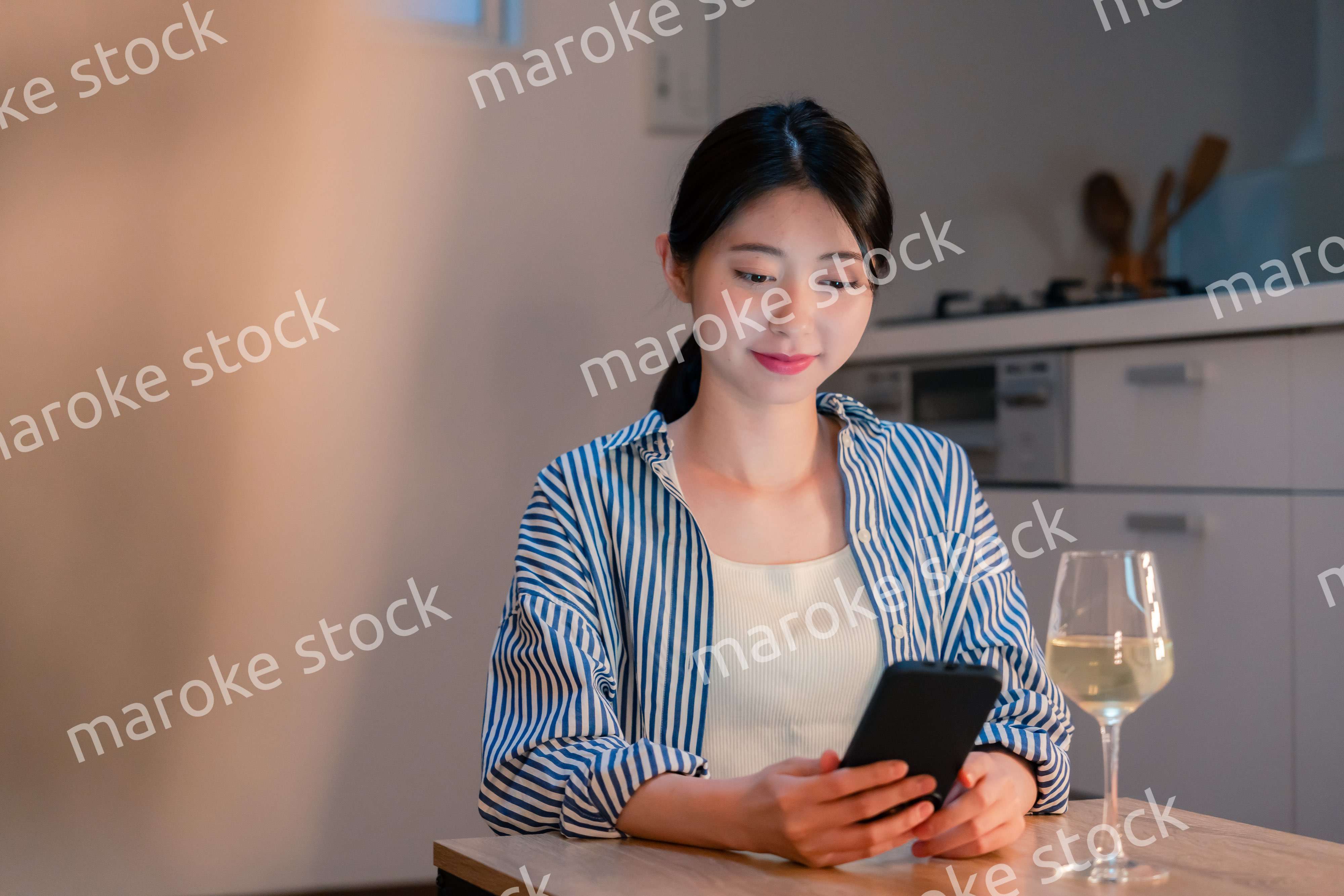 夜に一人で晩酌をする若い女性