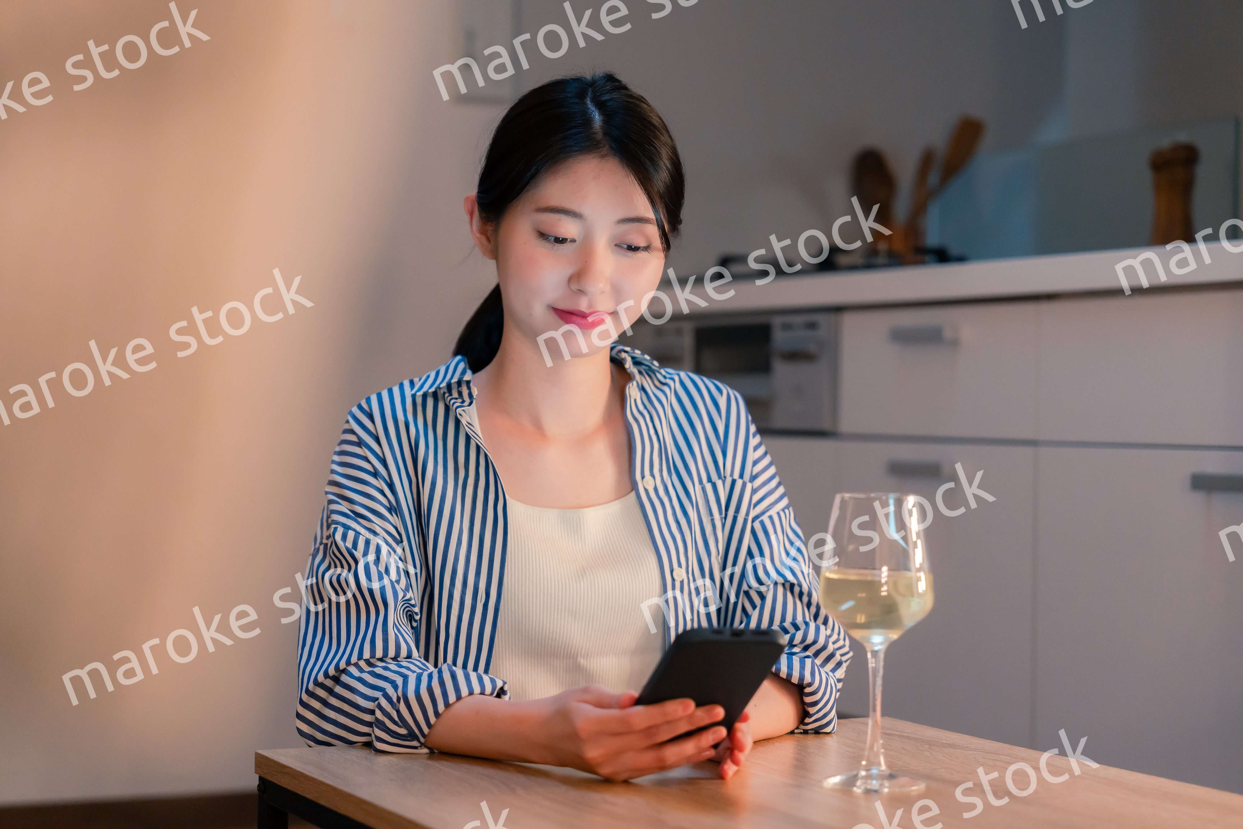 夜に一人で晩酌をする若い女性