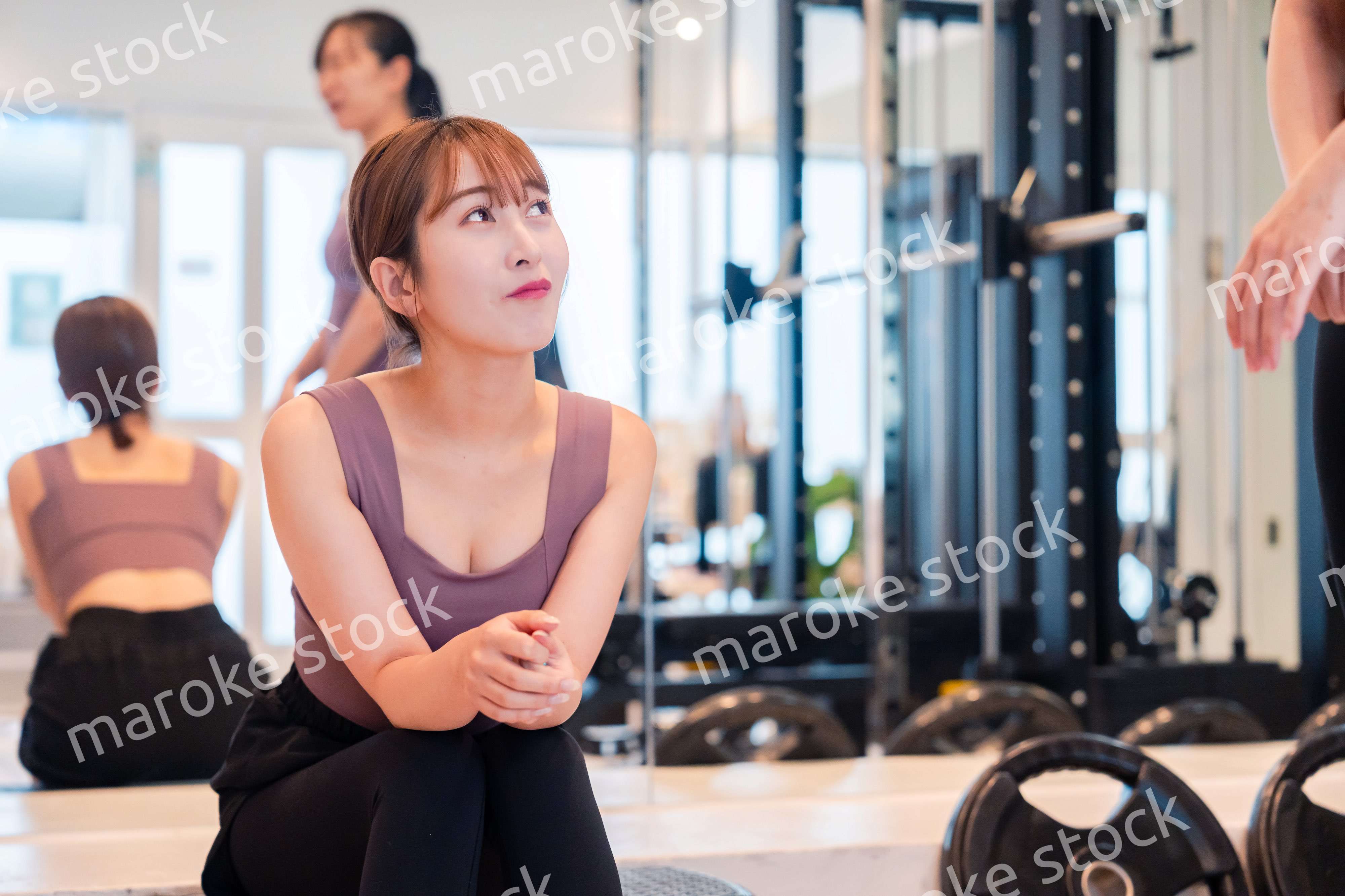 ジムで運動をしながら楽しく話をする女性