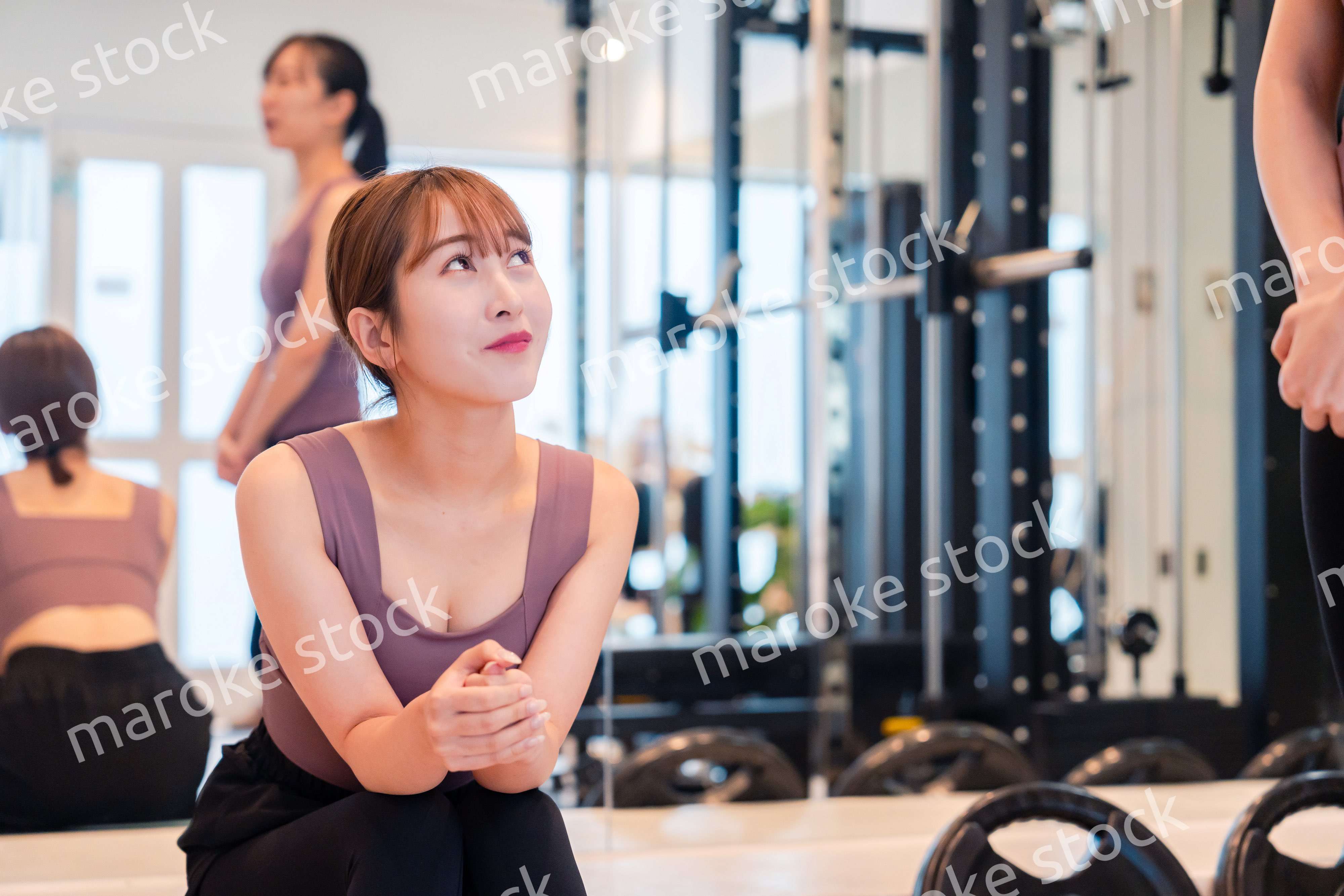 ジムで運動をしながら楽しく話をする女性