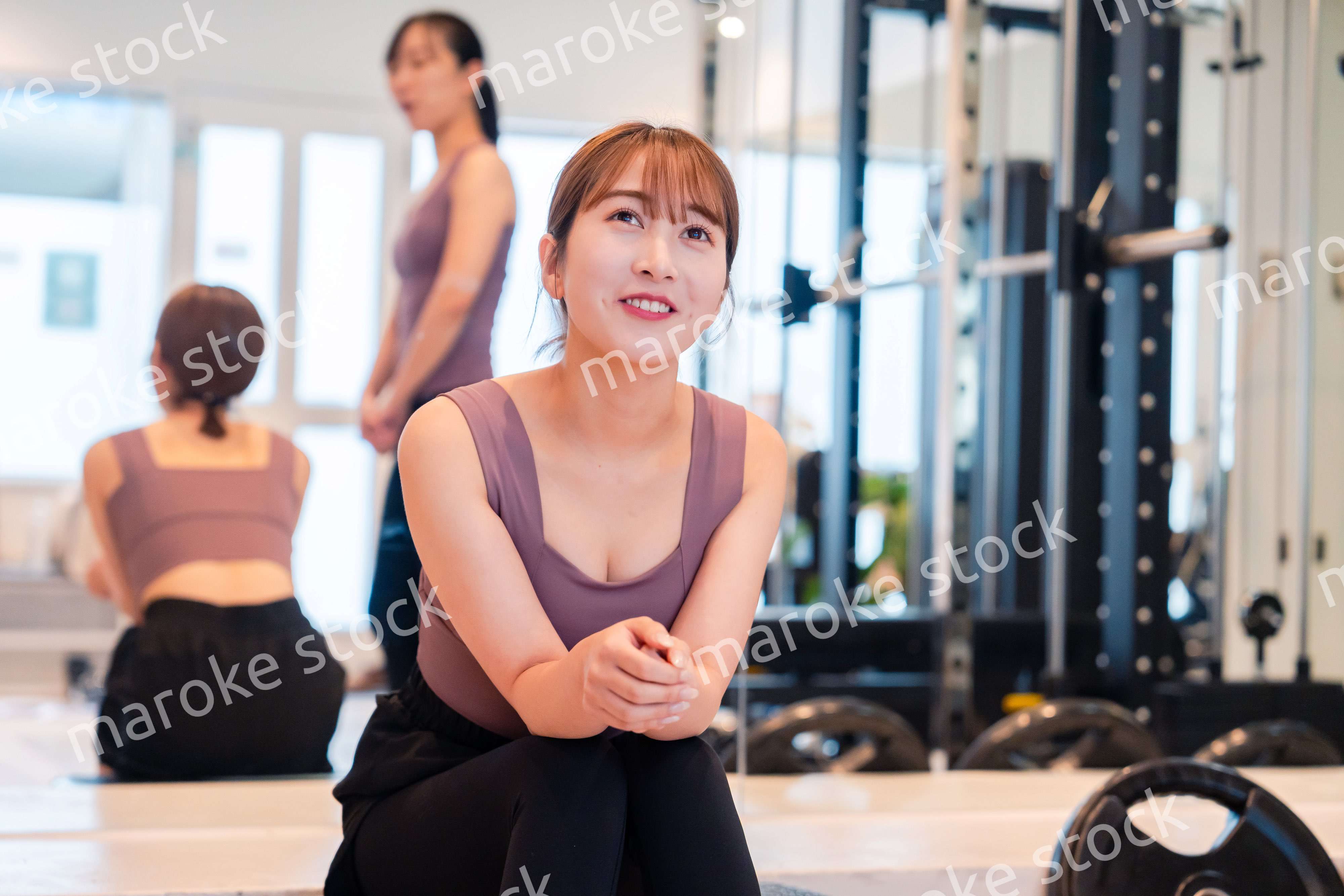 ジムで運動をしながら楽しく話をする女性