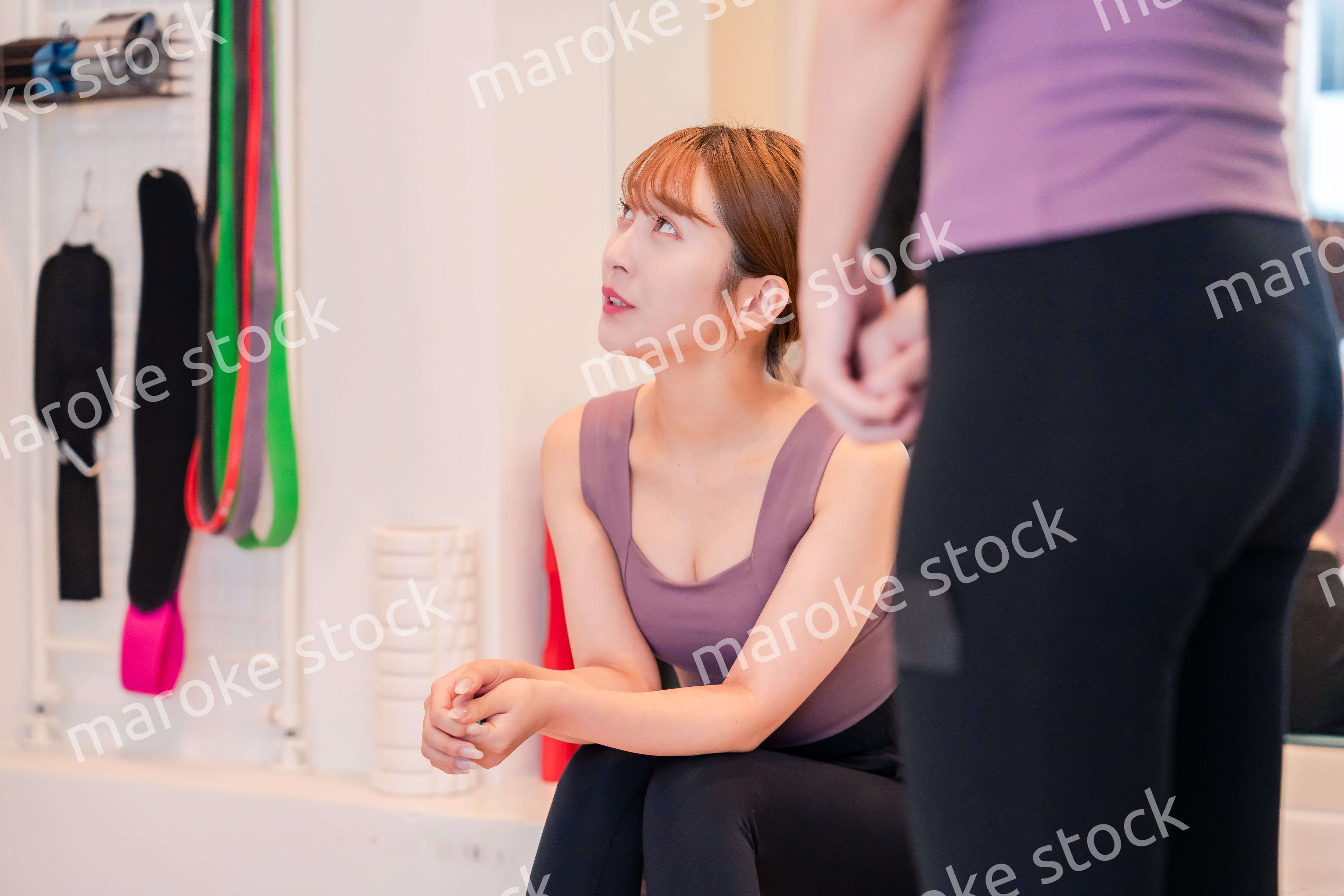 ジムで運動をしながら楽しく話をする女性