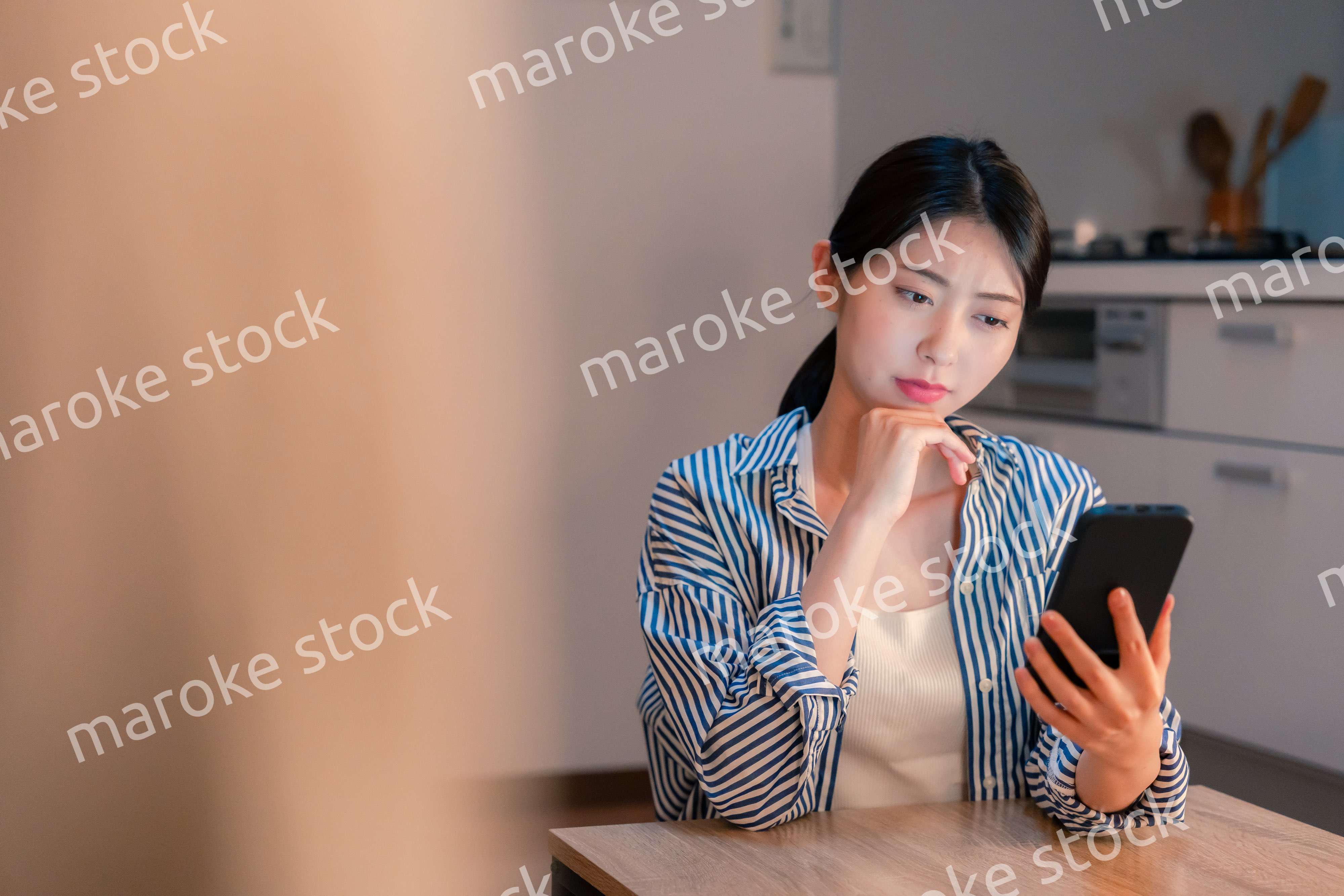 スマホを使いながら困った表情をする若い女性