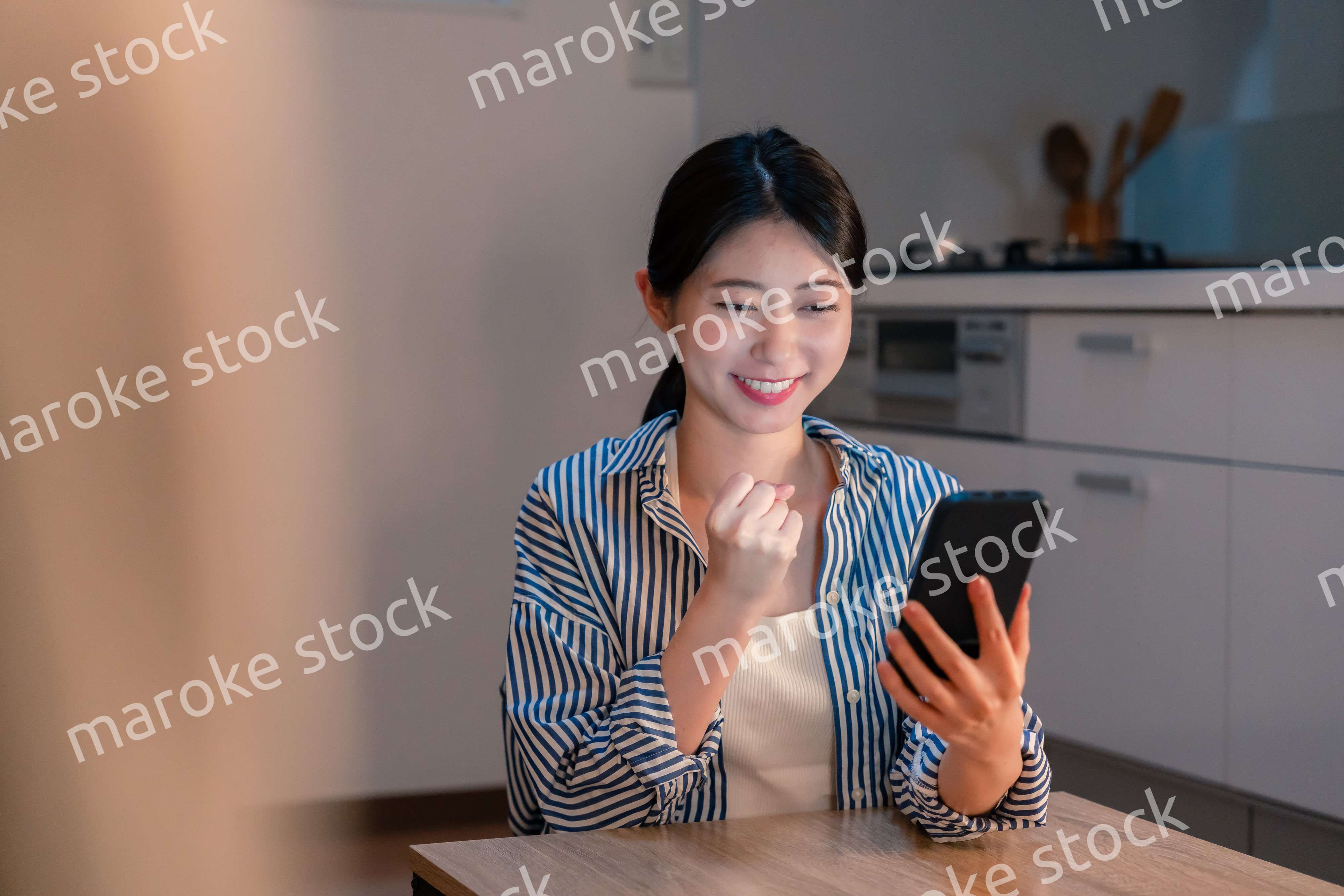 スマホを見ながら応援をする若い女性