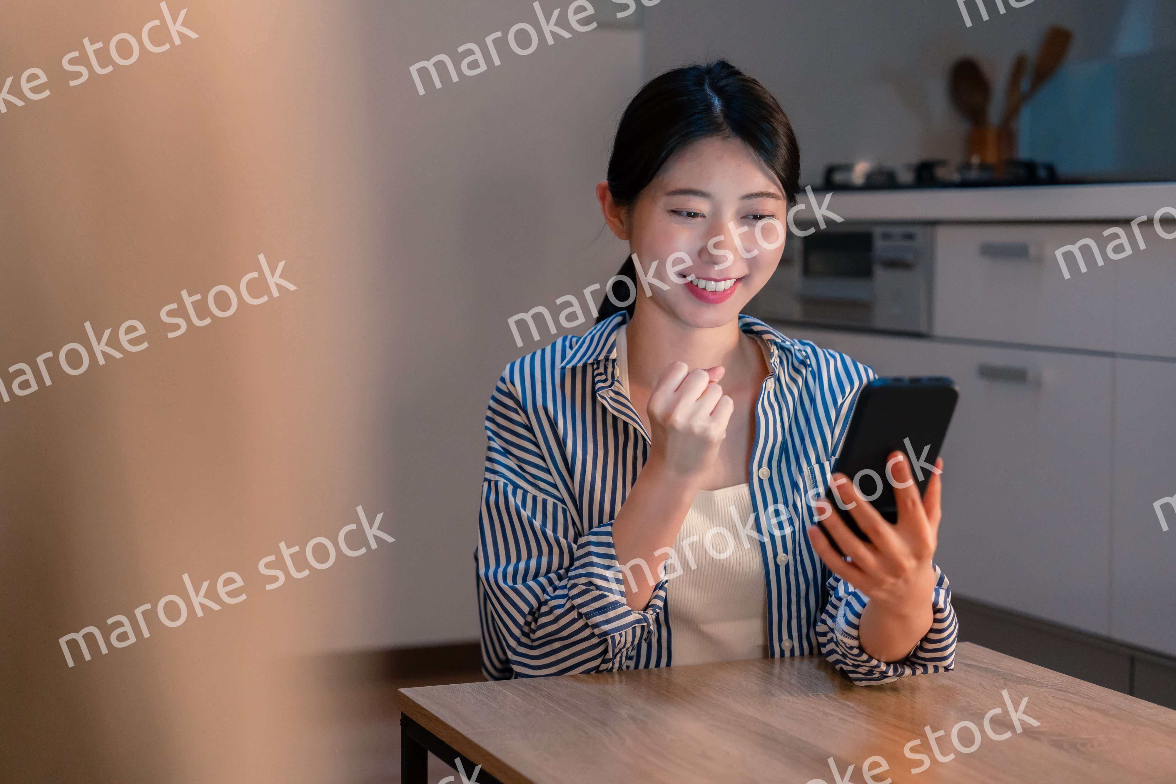 スマホを見ながら応援をする若い女性