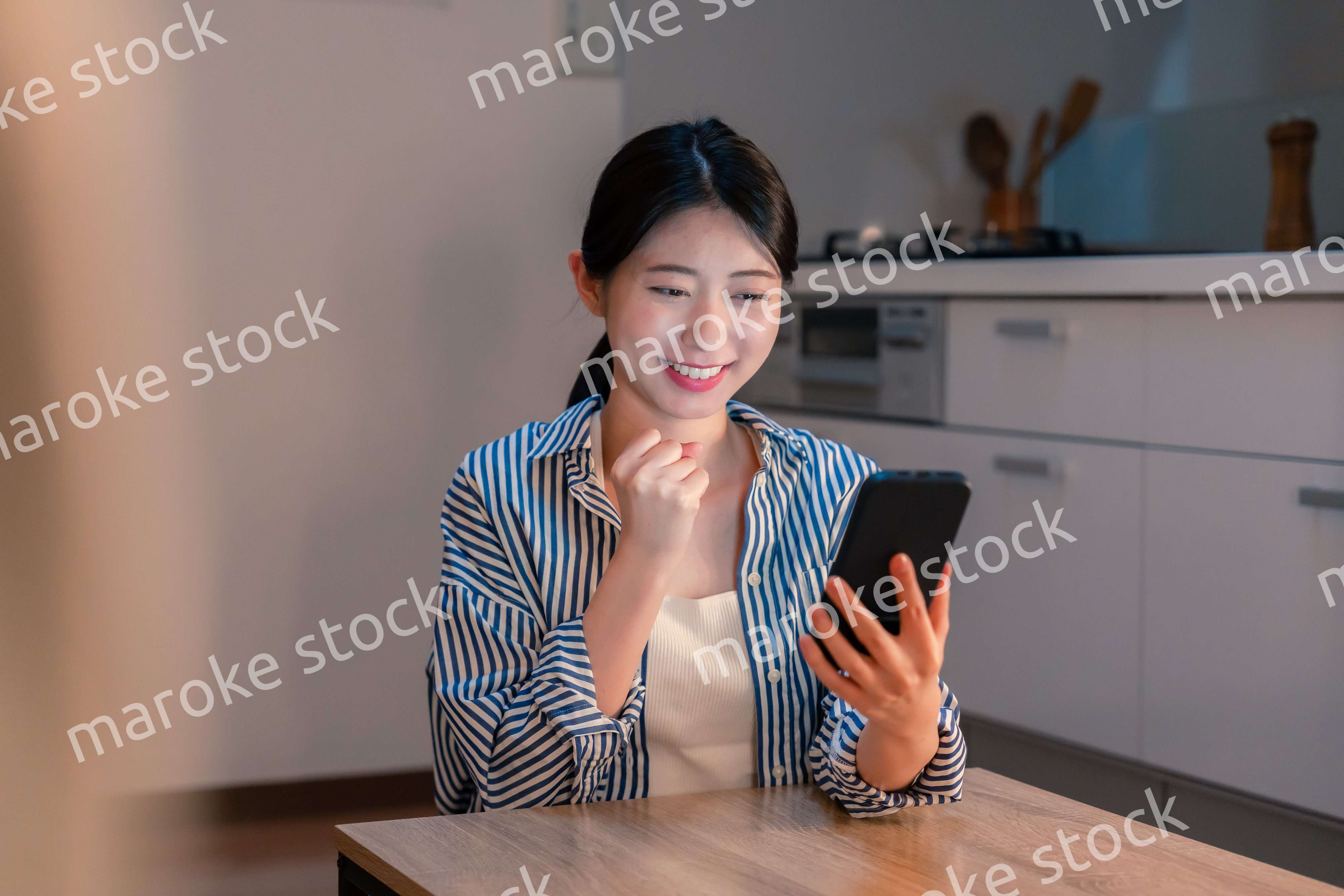 スマホを見ながら応援をする若い女性