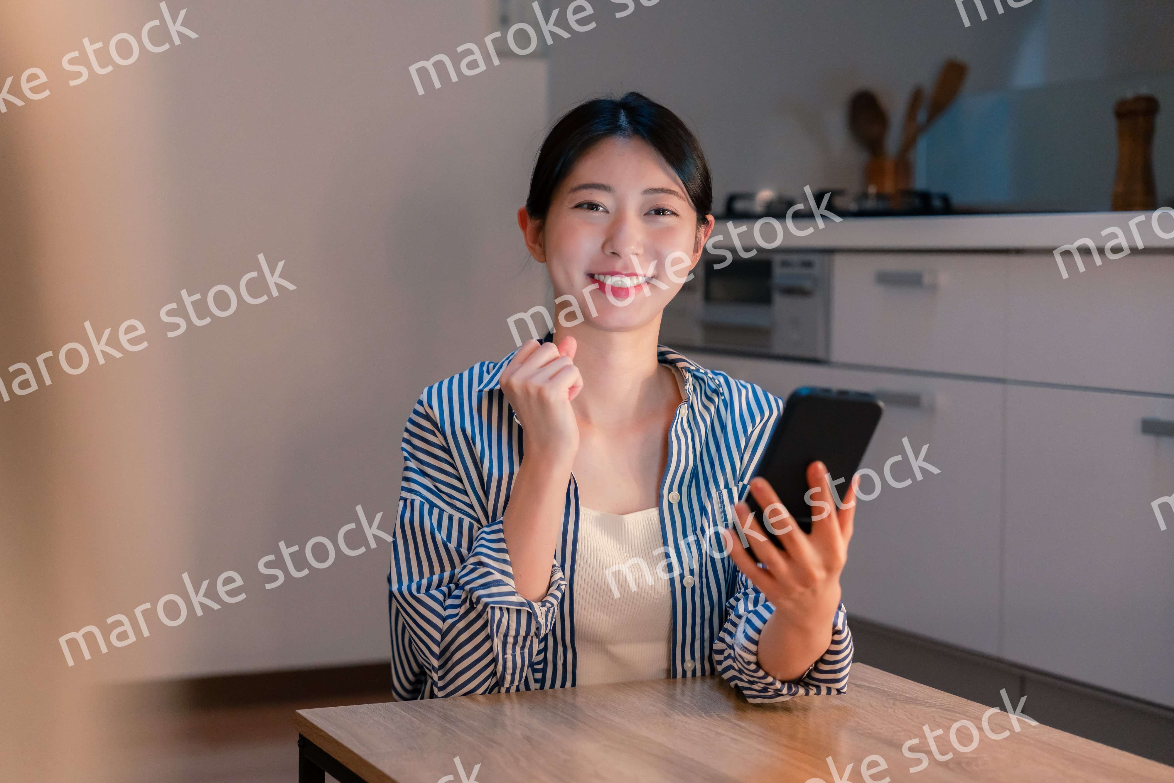 スマホを見ながら応援をする若い女性