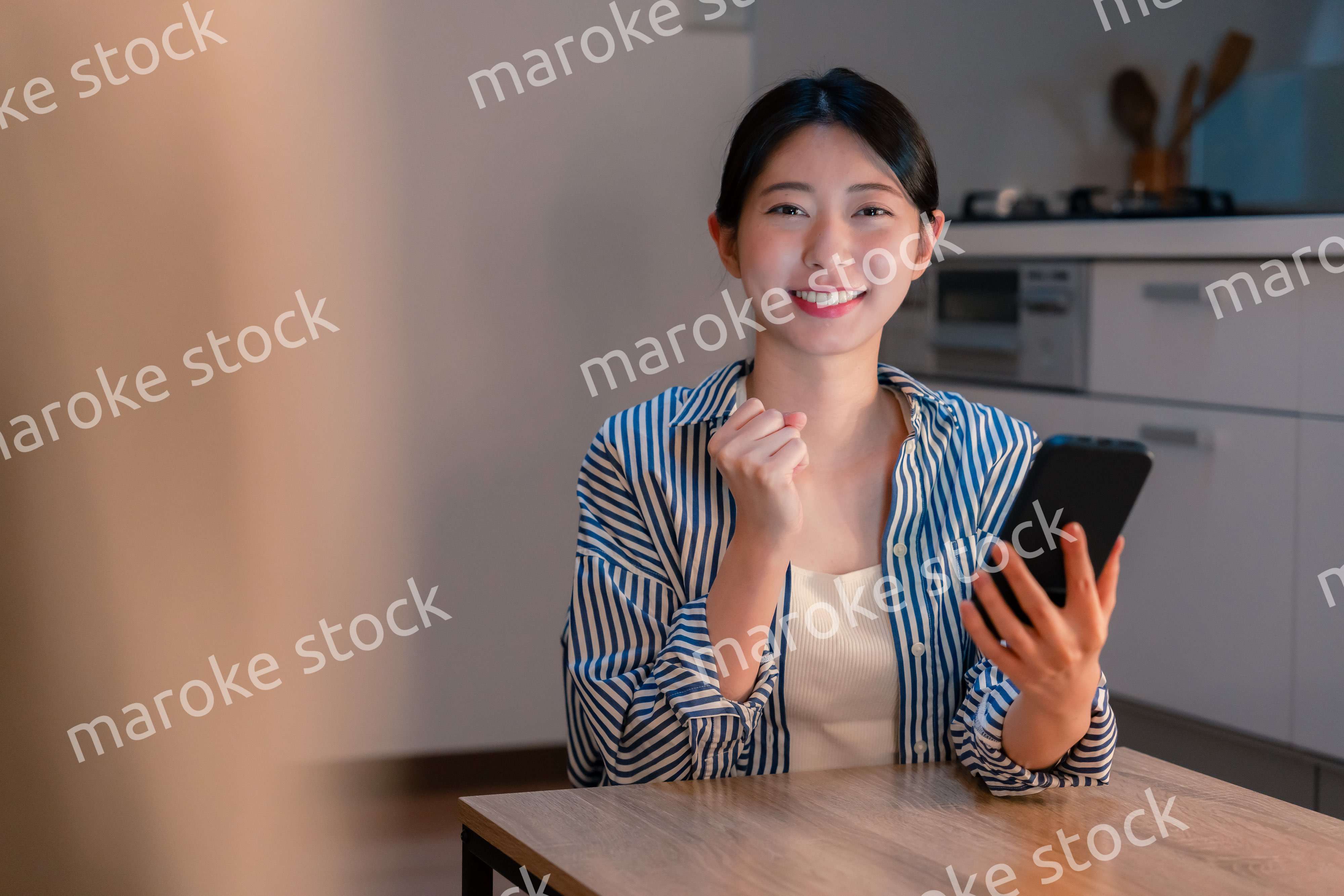 スマホを見ながら応援をする若い女性