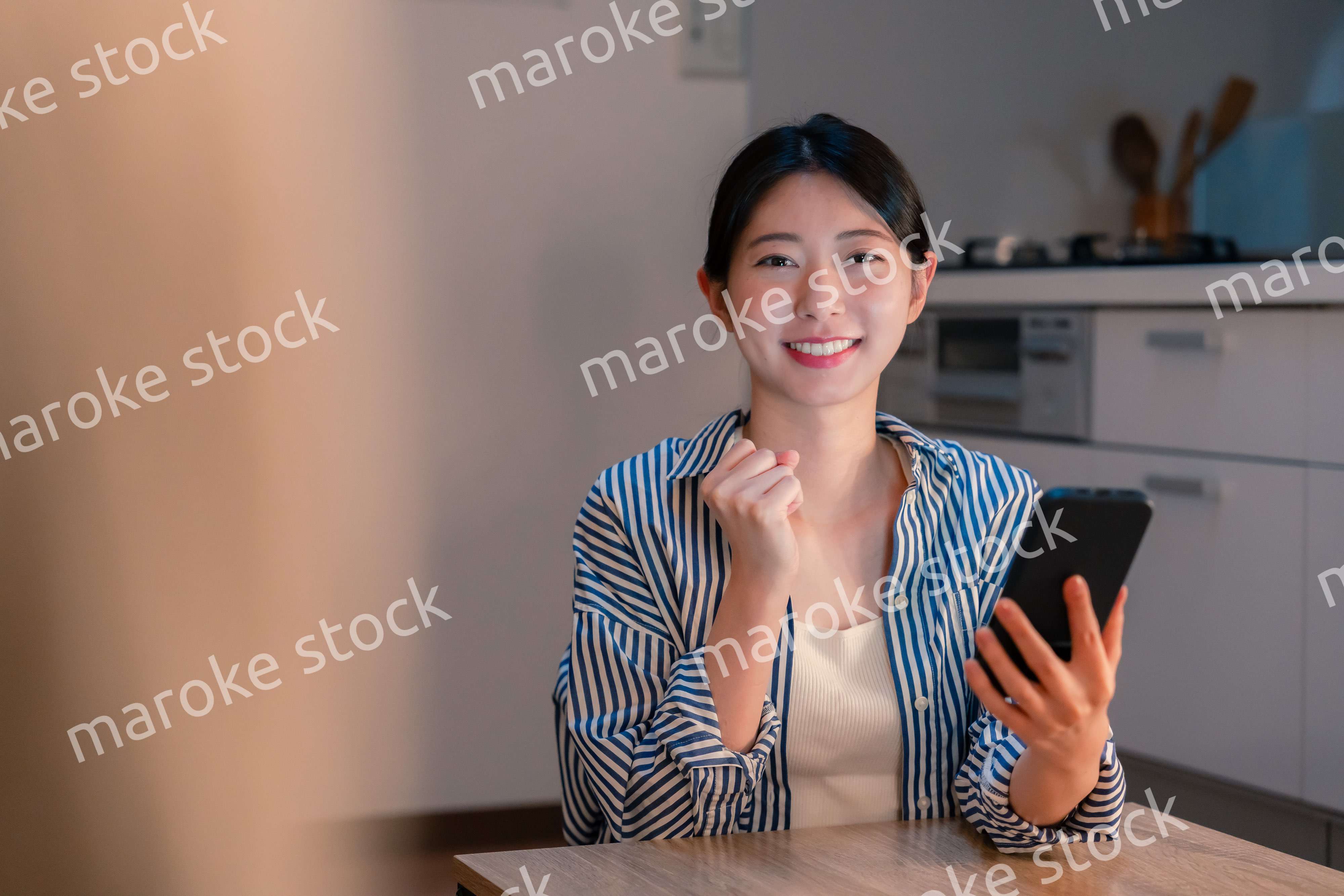 スマホを見ながら応援をする若い女性