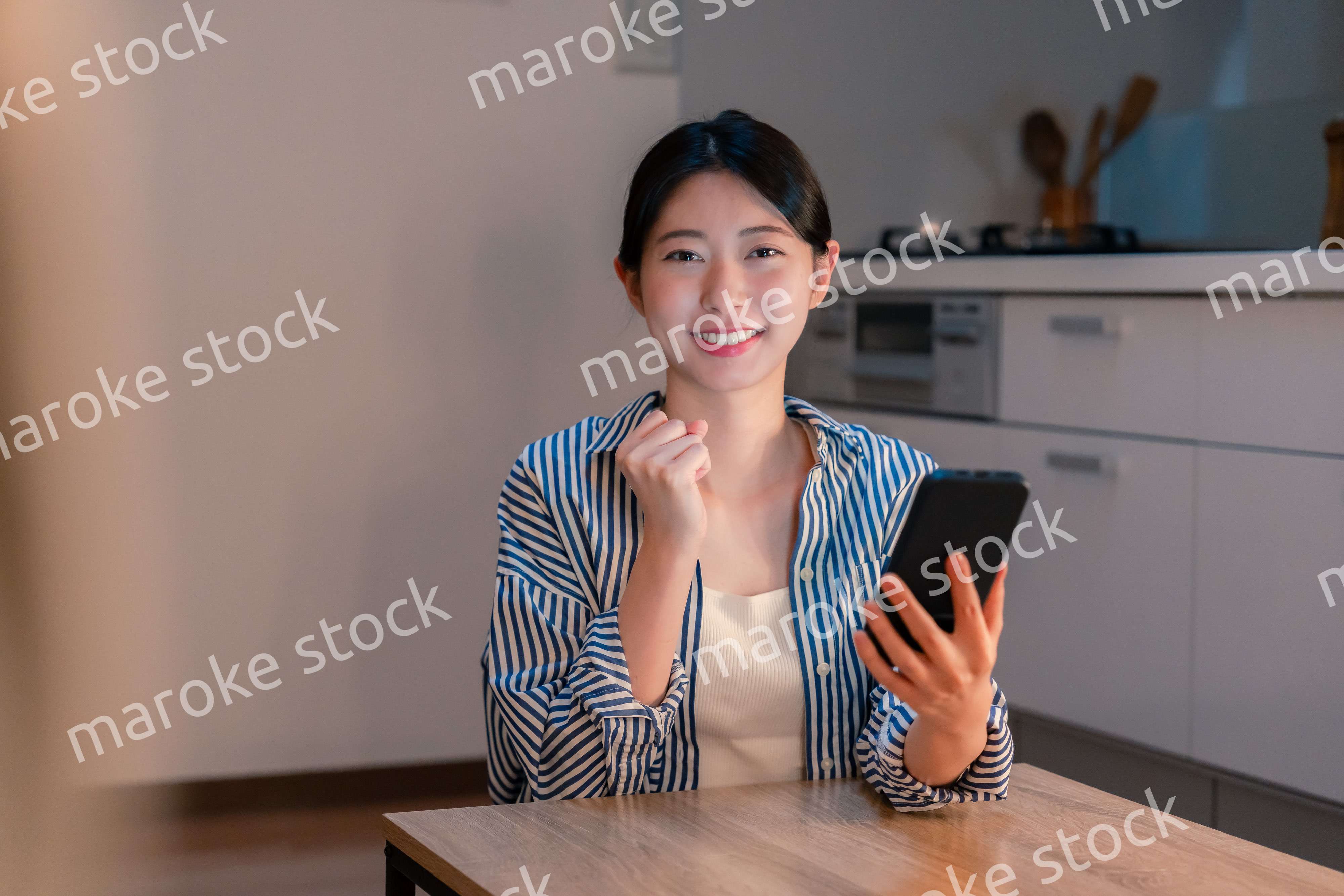 スマホを見ながら応援をする若い女性