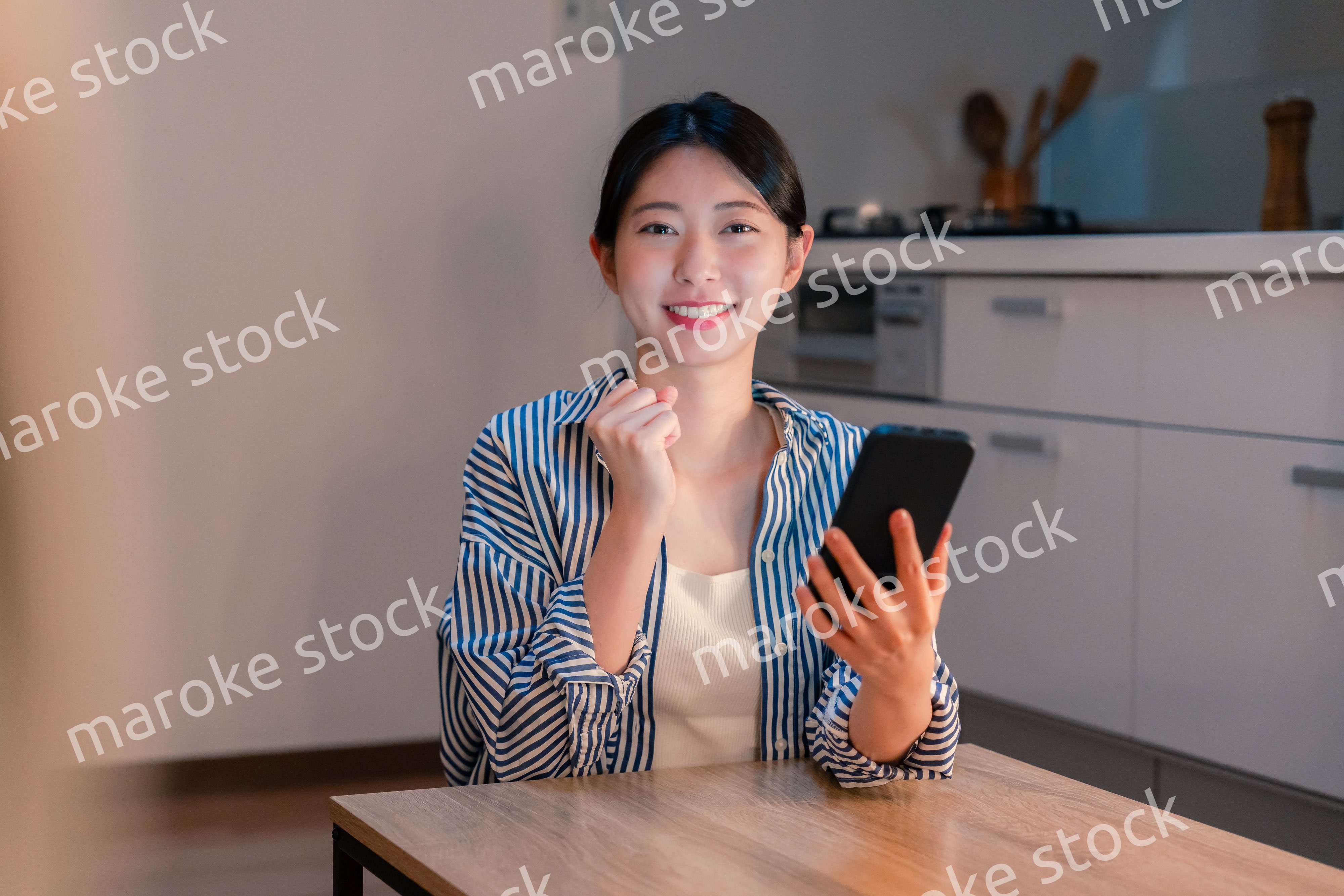 スマホを見ながら応援をする若い女性