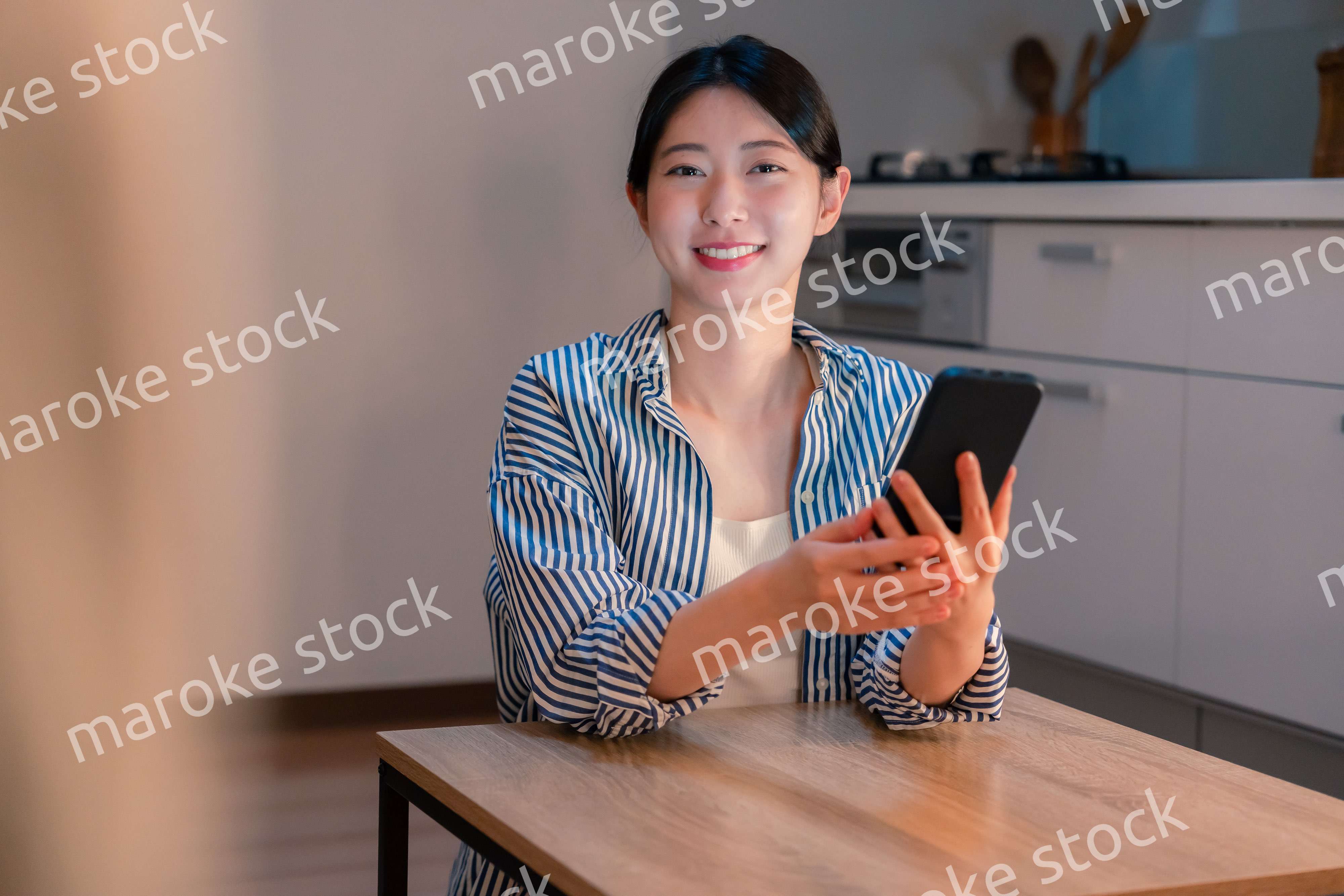 夜遅くに笑顔でスマホを使う若い女性