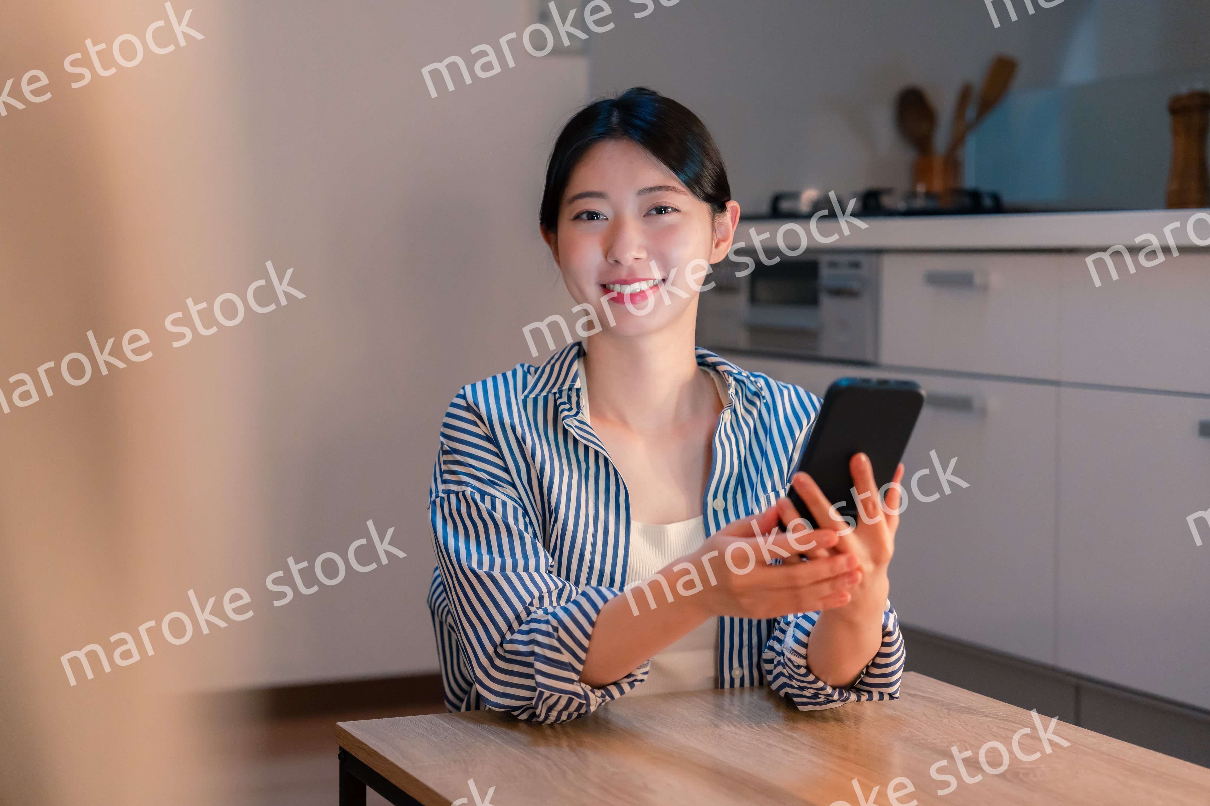 夜遅くに笑顔でスマホを使う若い女性