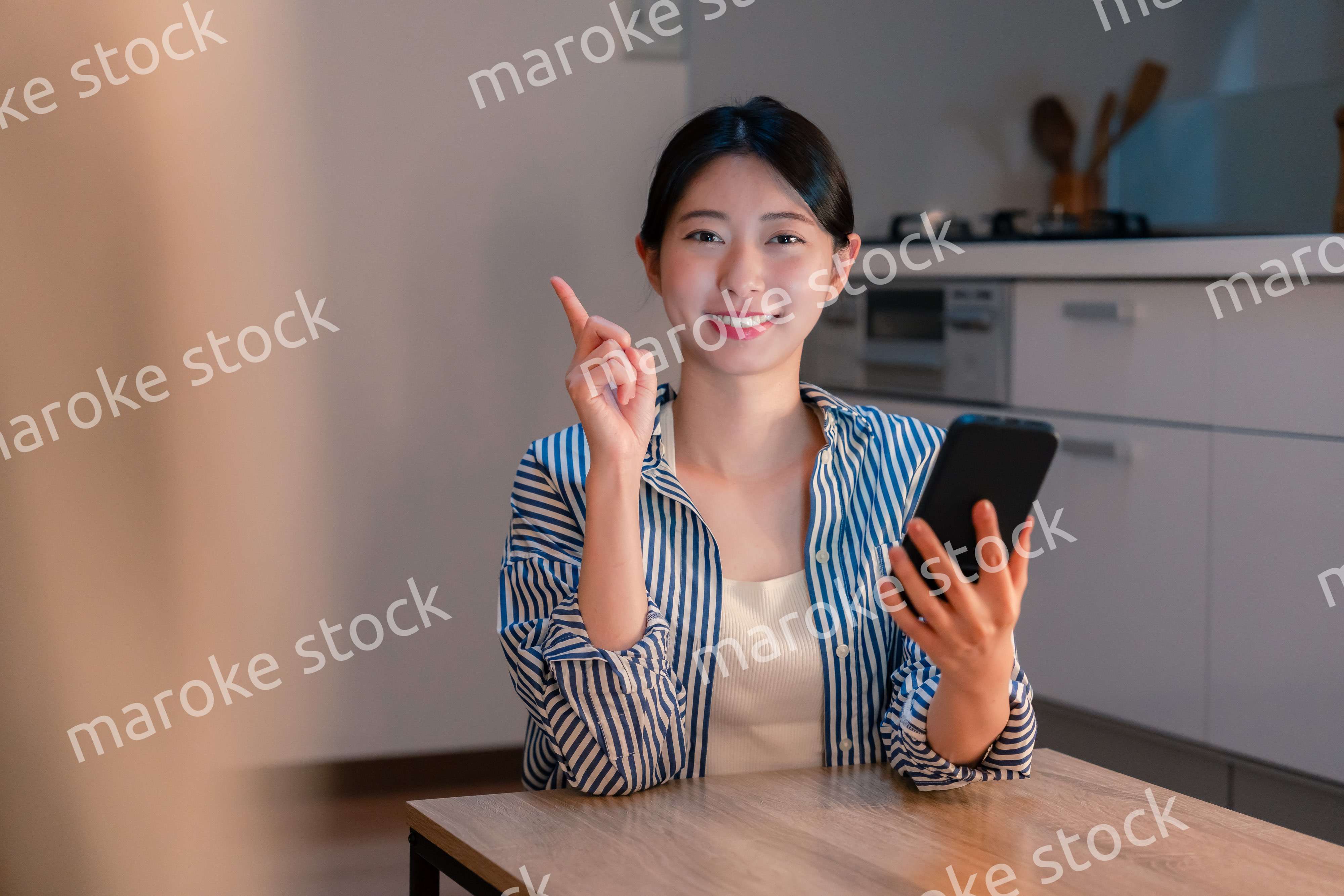 夜遅くに笑顔でスマホを使う若い女性