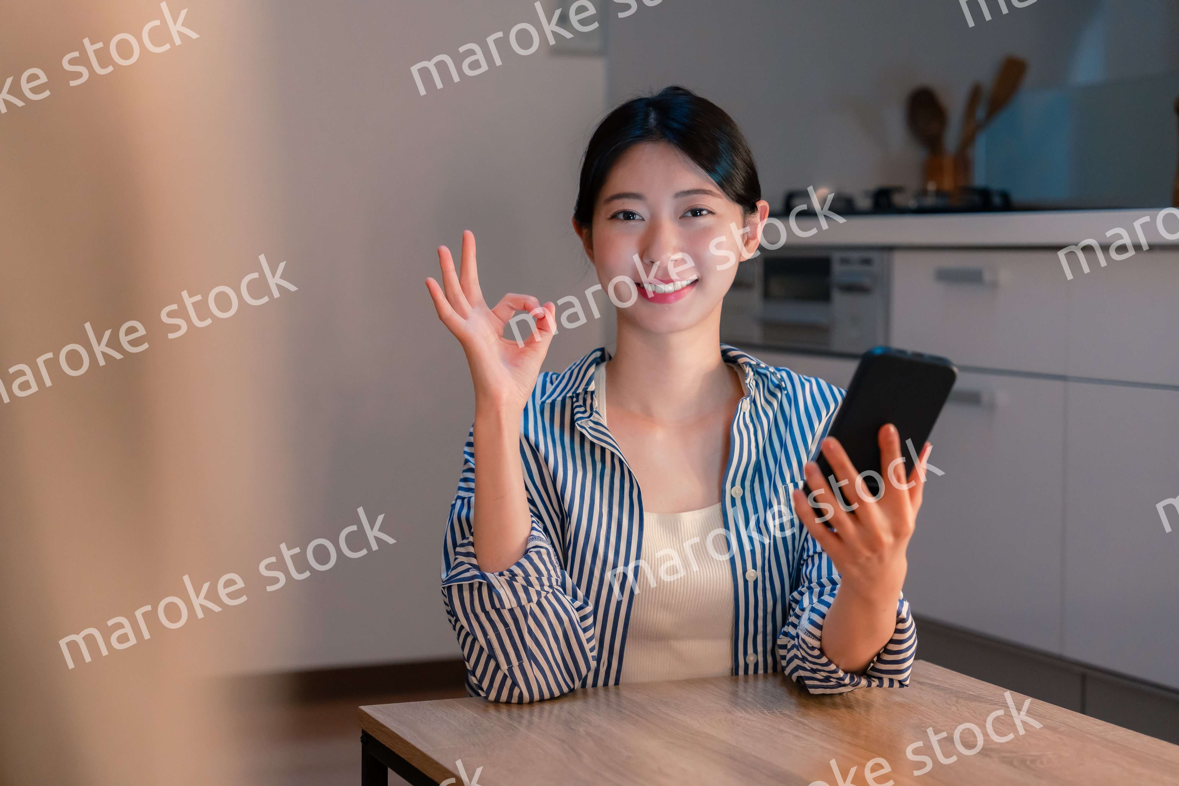 夜遅くに笑顔でスマホを使う若い女性