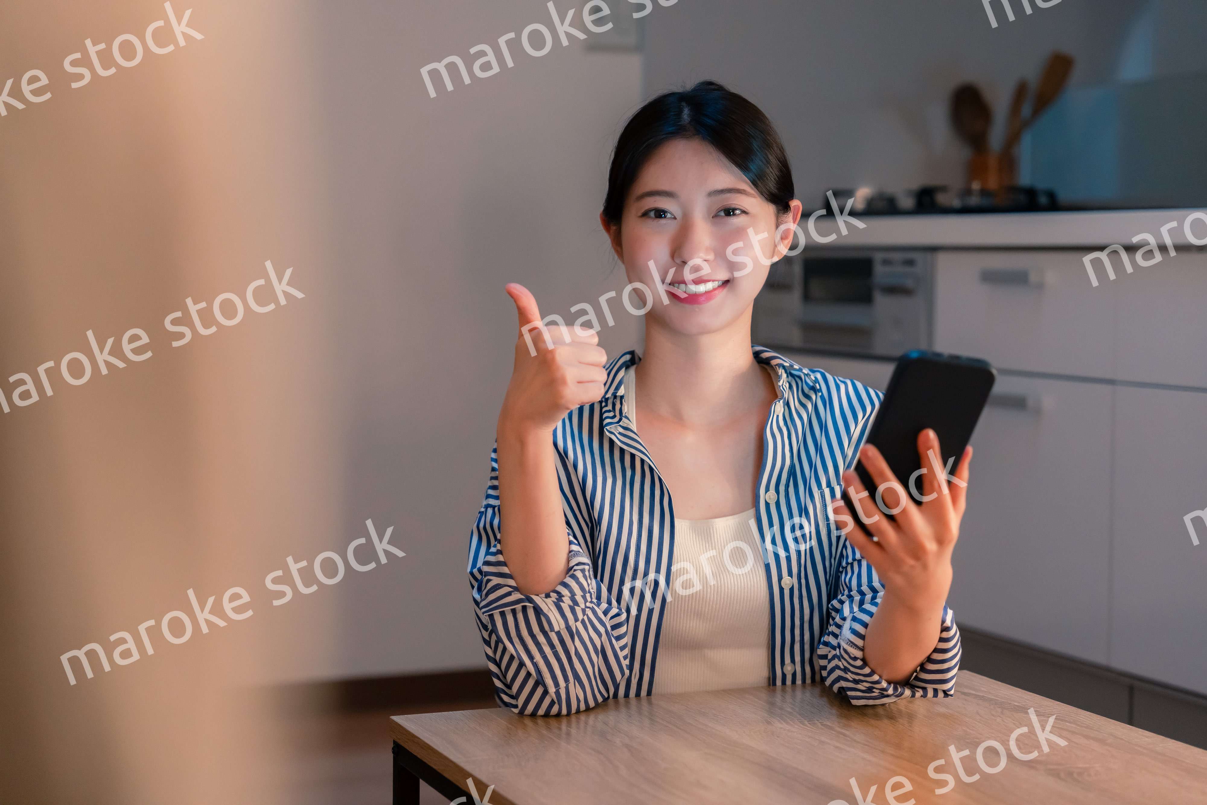 夜遅くに笑顔でスマホを使う若い女性