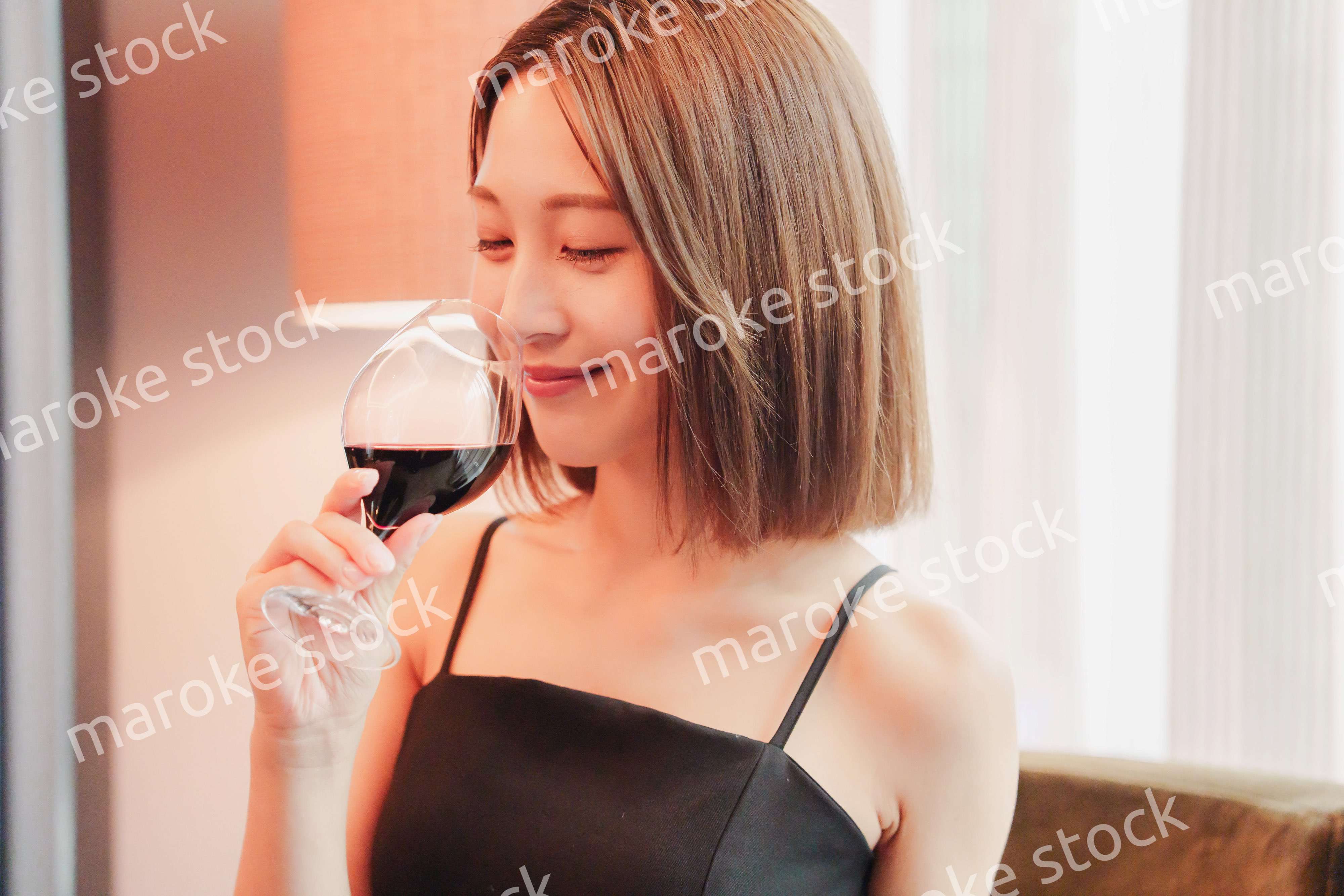 ホテルの客室でワインを楽しむ大人の女性