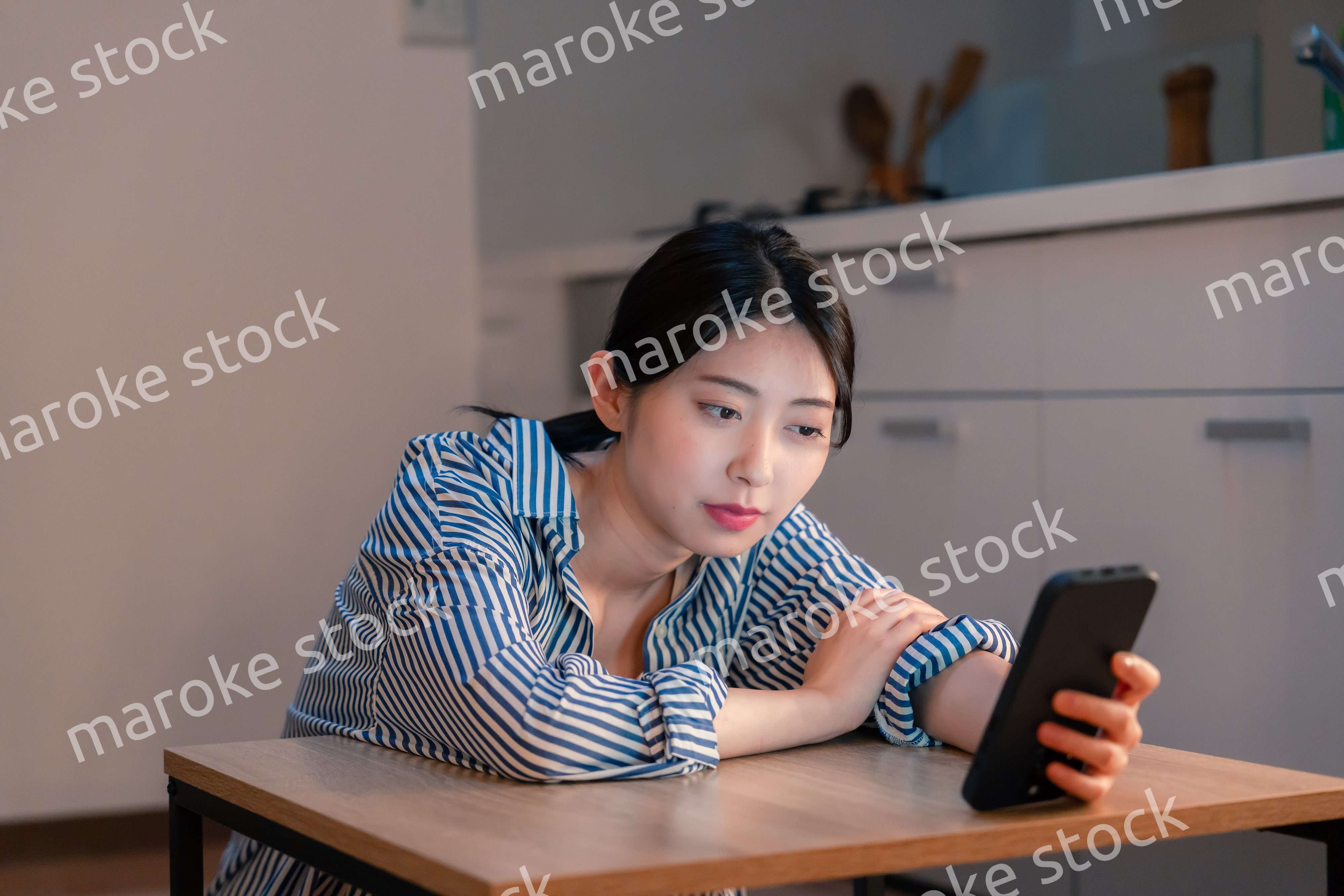 スマホを使いながら困った表情をする若い女性