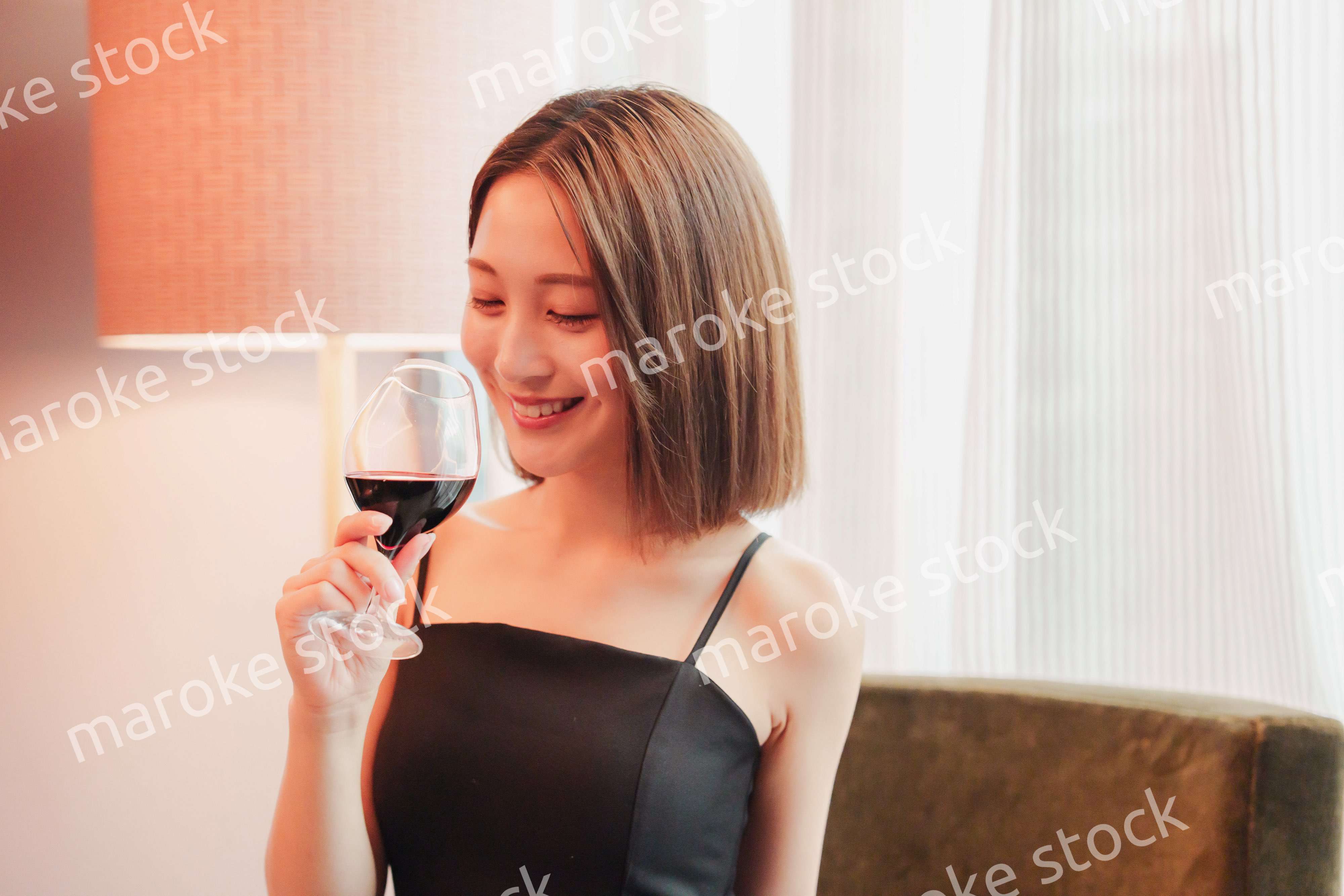 ホテルの客室でワインを楽しむ大人の女性