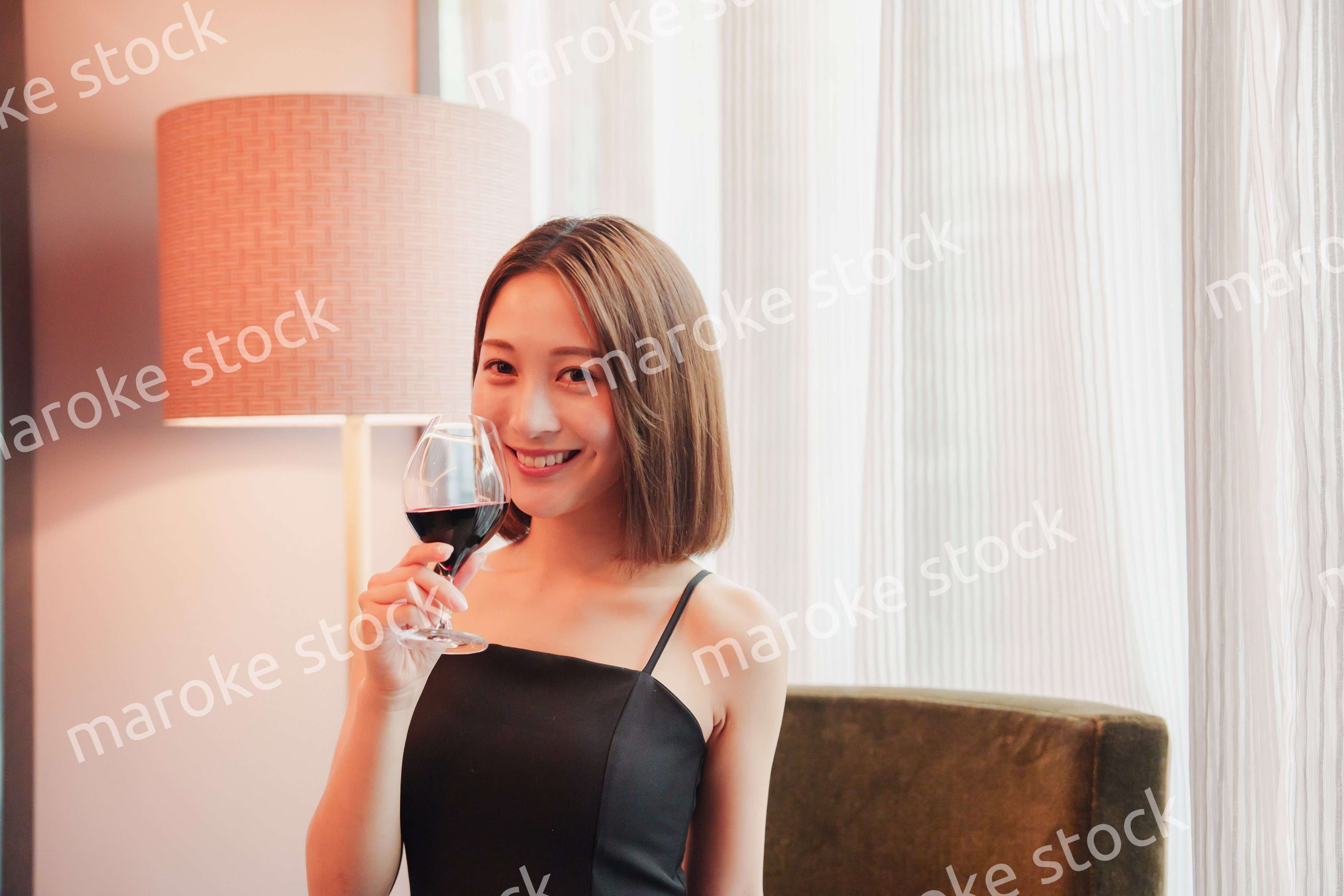 ホテルの客室でワインを楽しむ大人の女性