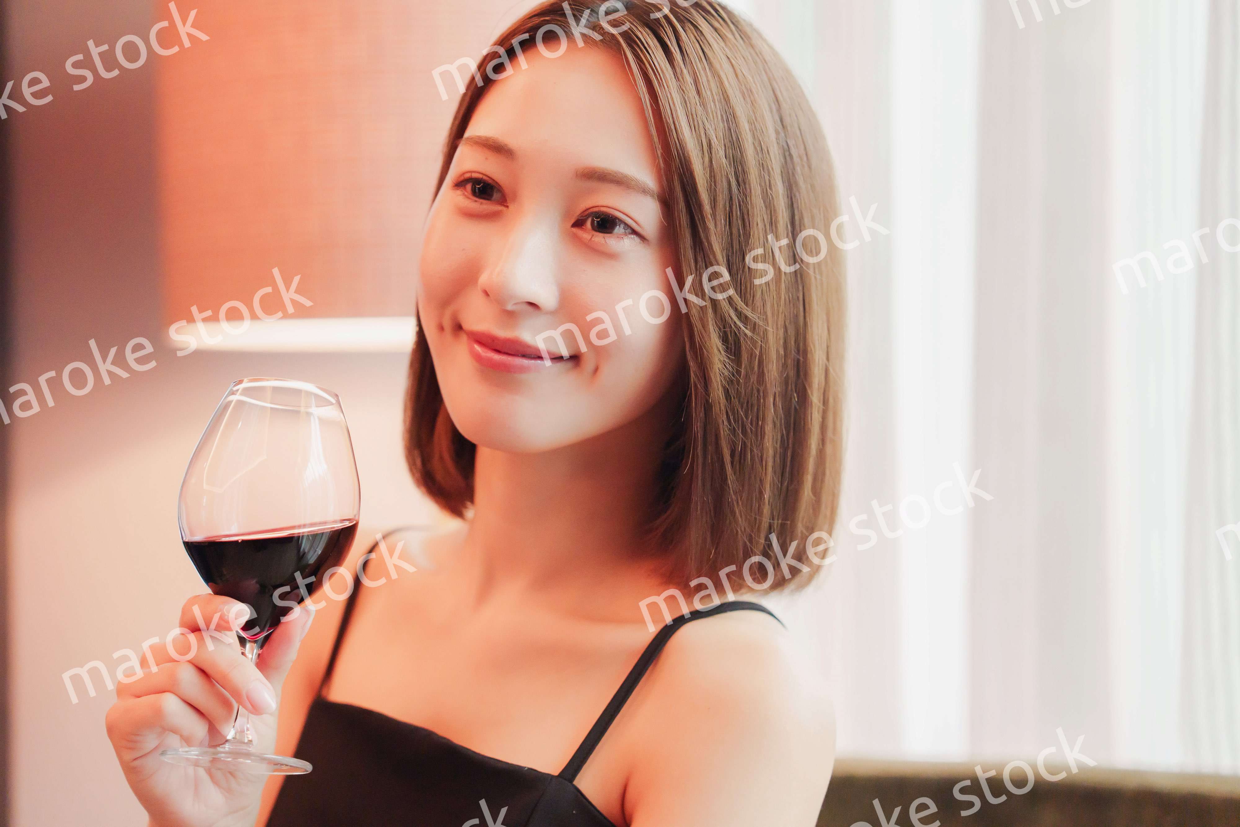 ホテルの客室でワインを楽しむ大人の女性